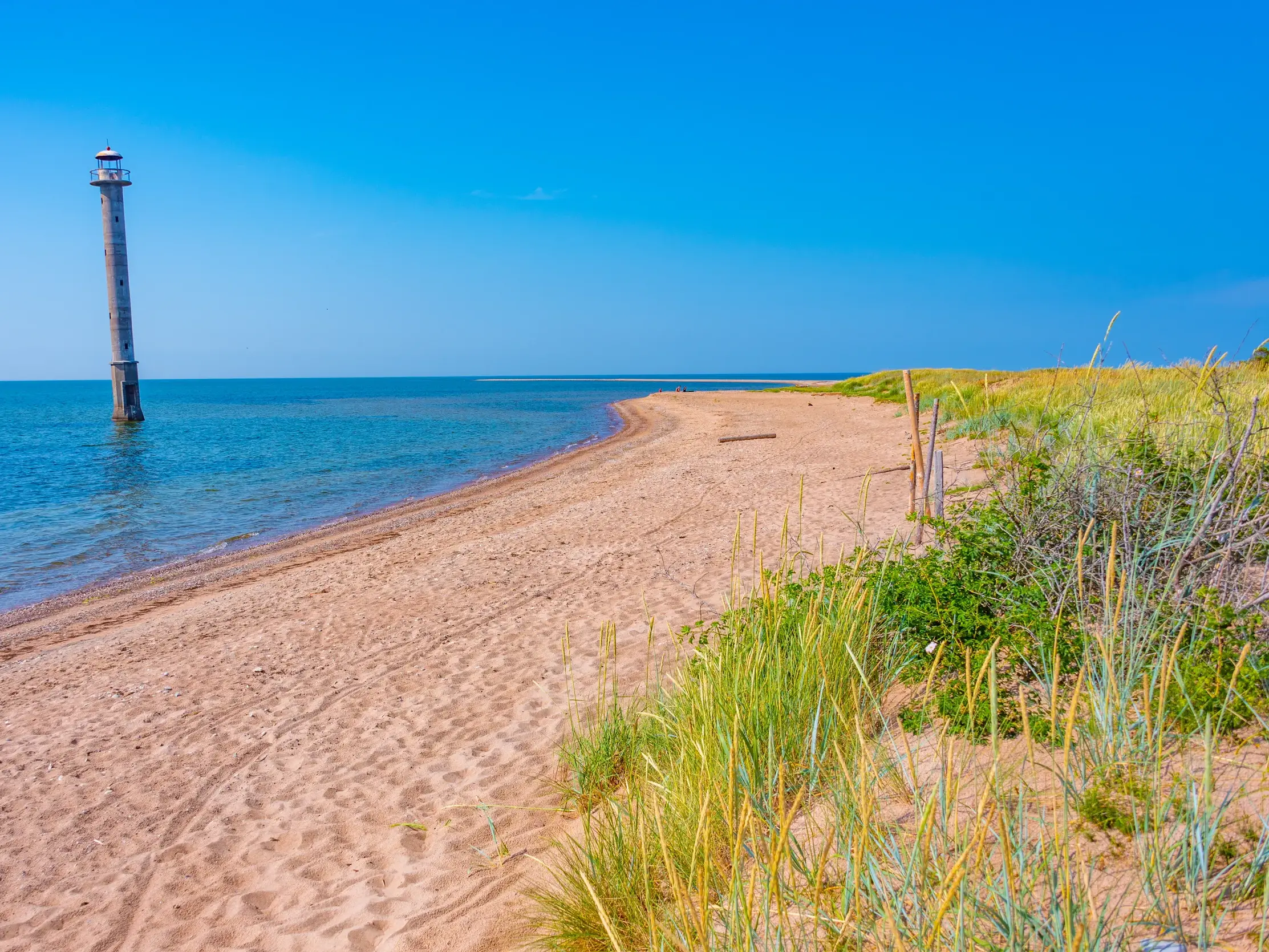 Der markante, schiefe Leuchtturm von Kiipsaare im Vilsandi-Nationalpark an einem sonnigen Sandstrand der Ostsee.