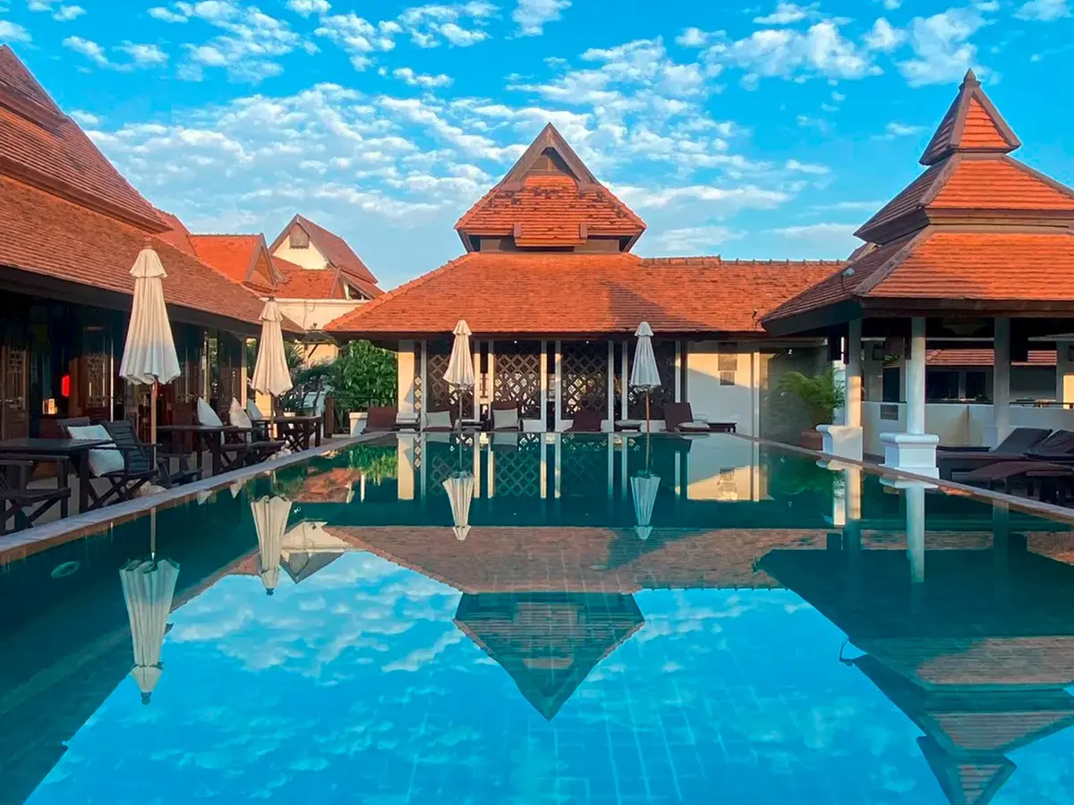 Die Gebäude des Bodhi Serene Boutique Hotels spiegeln sich im Poolwasser.
