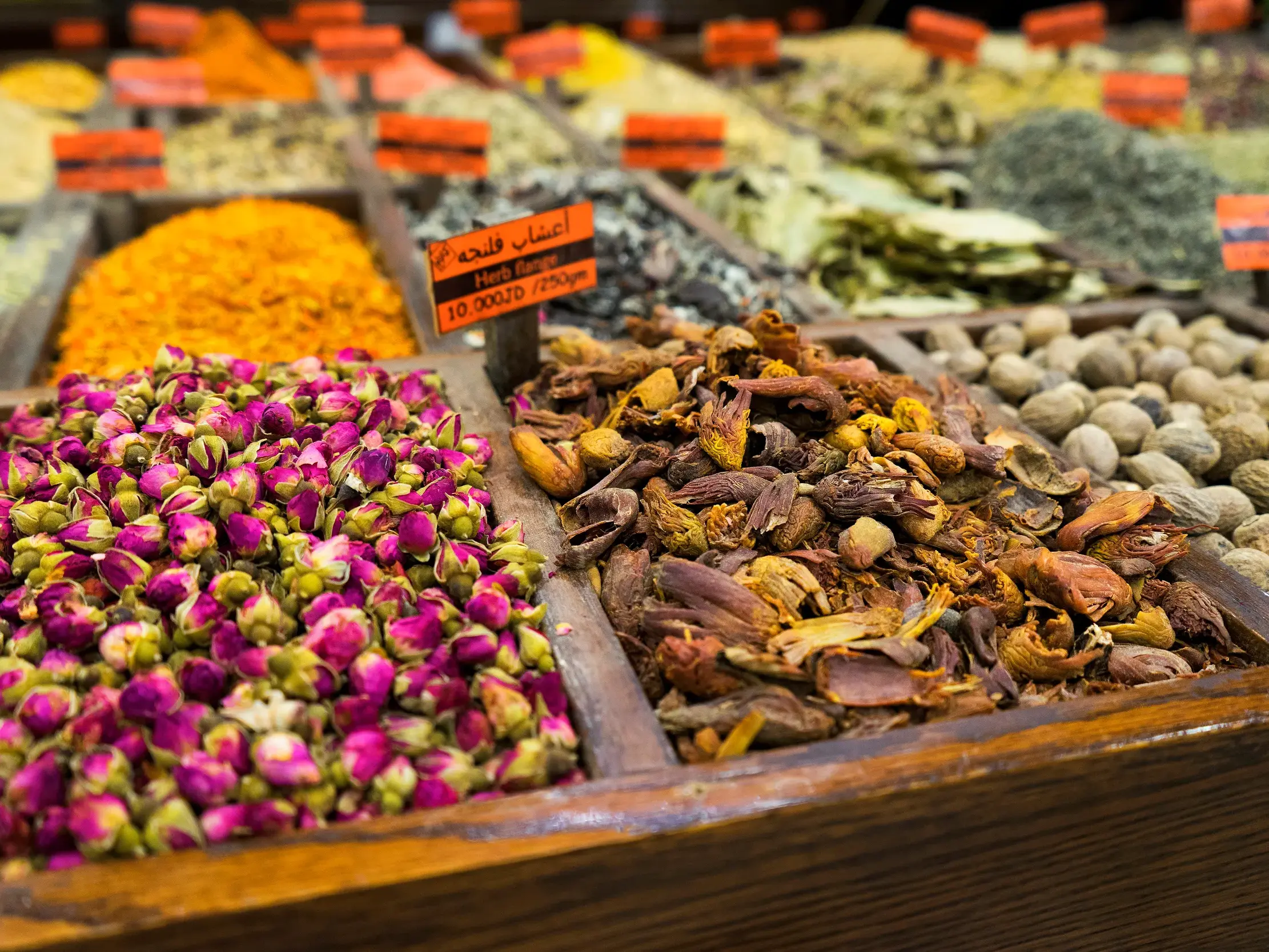 Vielfalt orientalischer Gewürze, Kräuter und Blüten in Holzkisten auf einem Souk in Amman während einer Studienreise.