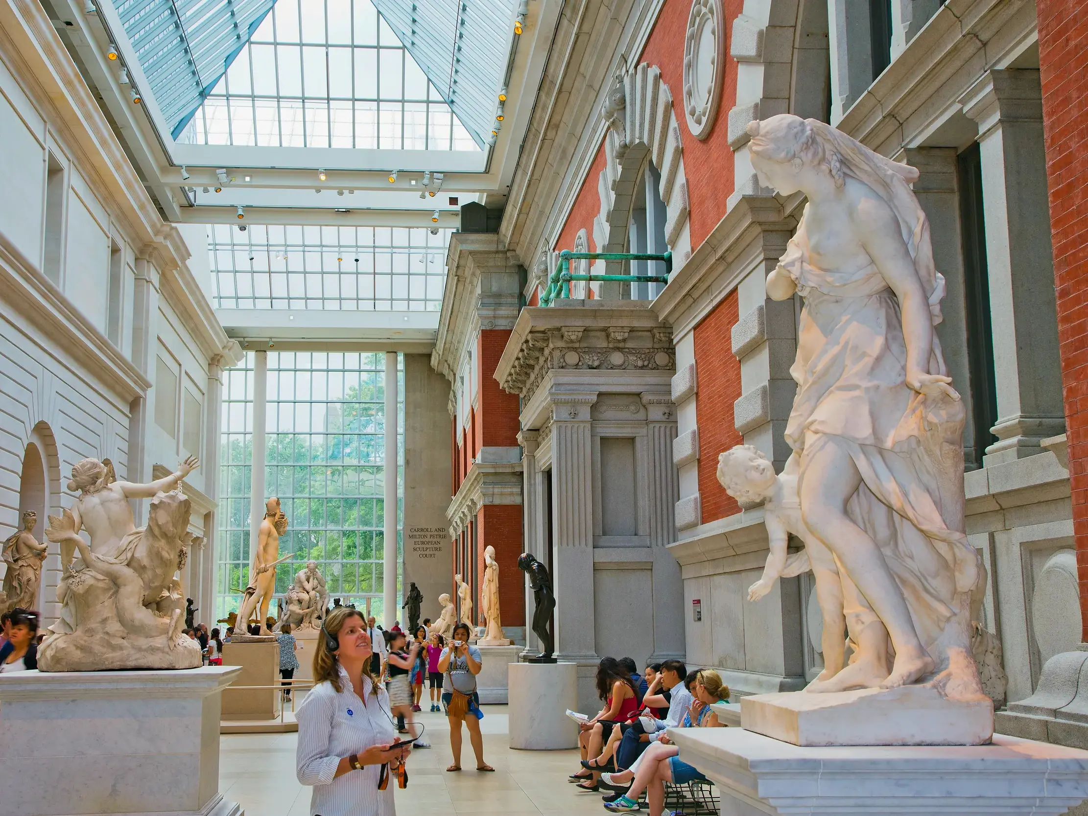 Besucher im lichtdurchfluteten Skulpturensaal des Metropolitan Museum of Art in New York.