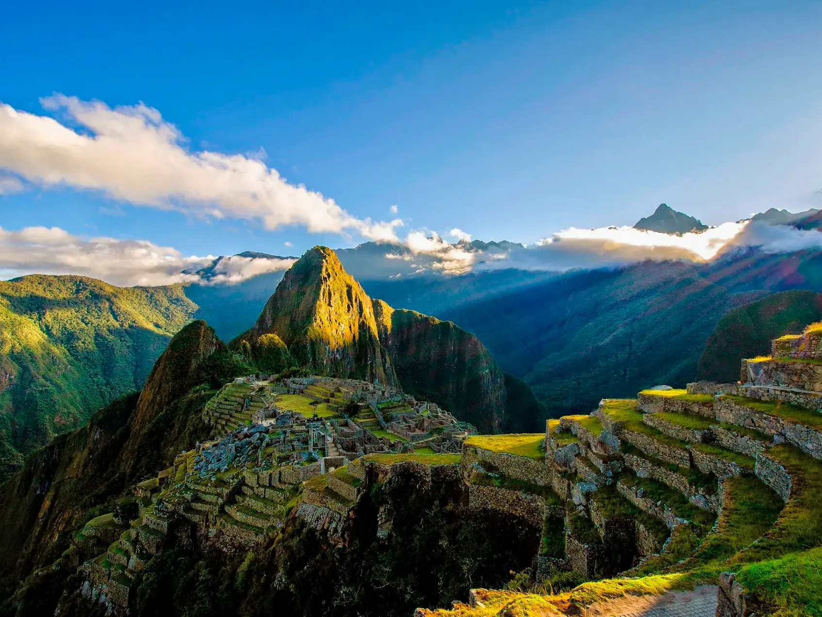 Die Ruinen der Inkastadt Machu Picchu in den Anden von Peru, mit dem Berg Huayna Picchu im morgendlichen Sonnenlicht.