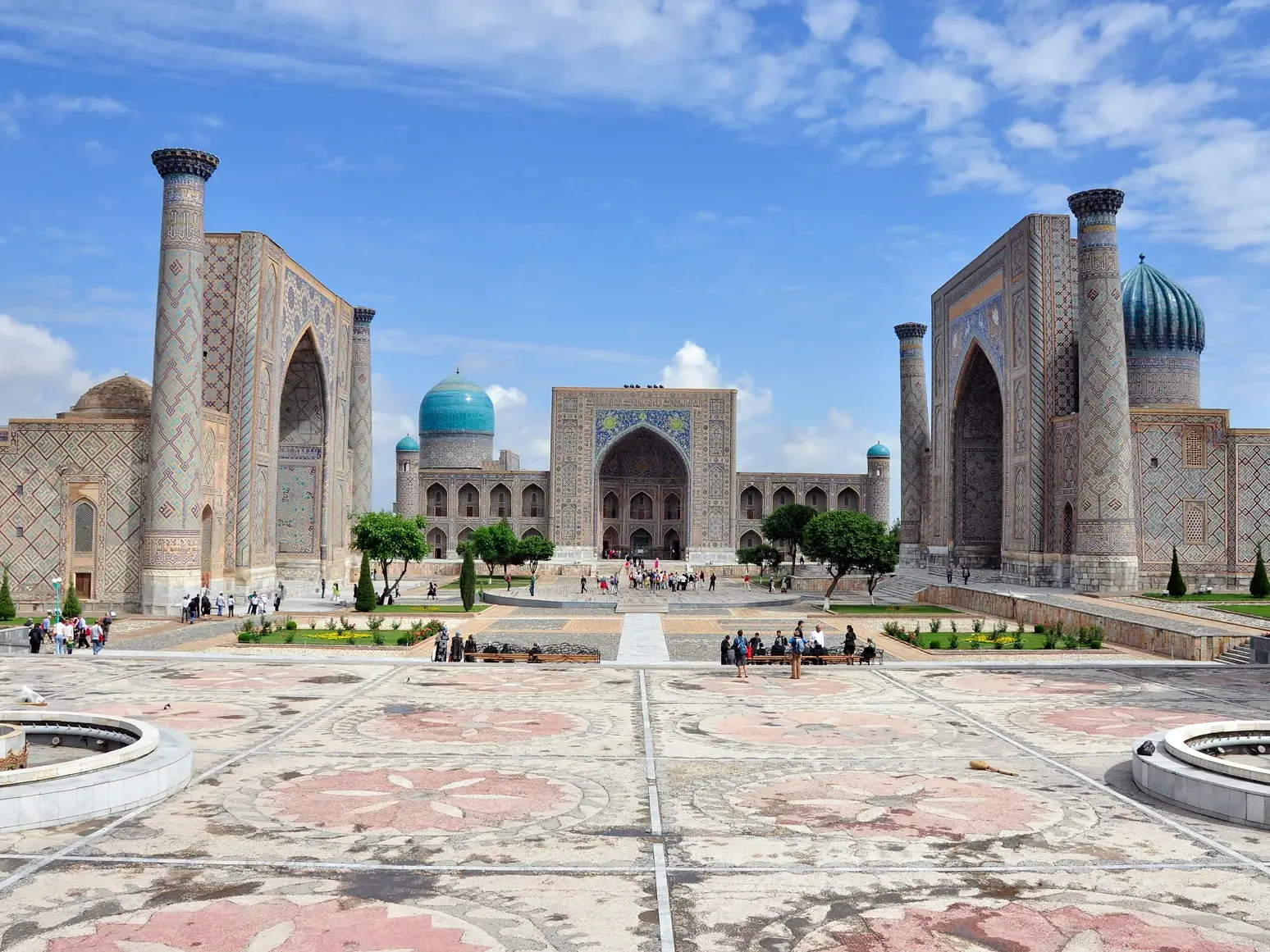Besucher auf dem historischen Registan-Platz in Samarkand bestaunen die drei prächtigen Medresen der Seidenstraße.