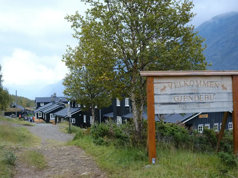 Hölzernes Willkommensschild an der Berghütte Gjendebu im Jotunheimen Nationalpark, dem Ausgangspunkt für eine Trekking-Etappe.
