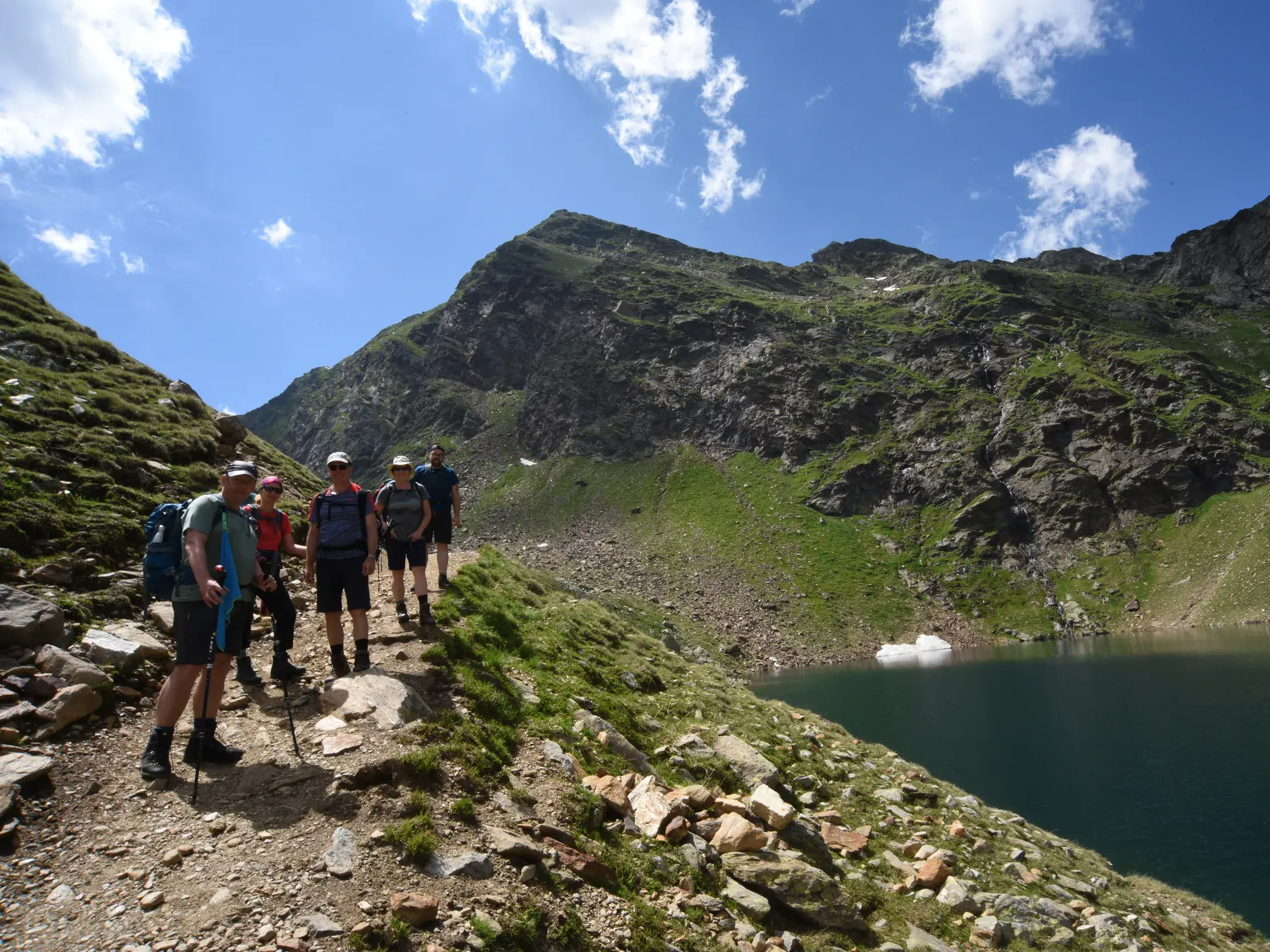 Eine Wandergruppe auf einem schmalen Pfad bei einer Trekking-Pause an den Spronser Seen in der Texelgruppe, Südtirol.