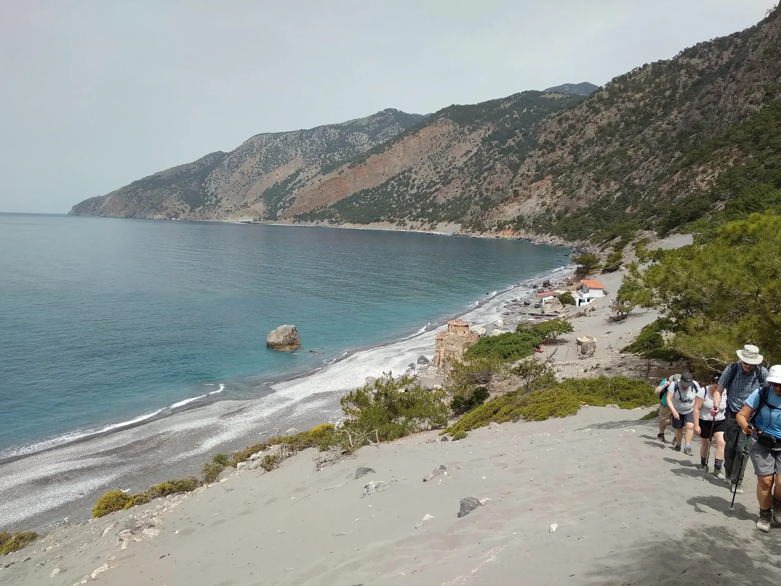 Wanderer auf dem Küstenpfad E4 an Kretas Südküste steigen hinab zum türkisfarbenen Meer am Strand Agios Pavlos.