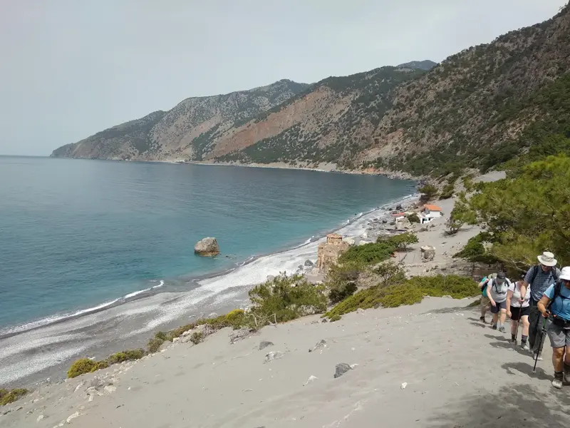 Wanderer auf dem Küstenpfad E4 an Kretas Südküste steigen hinab zum türkisfarbenen Meer am Strand Agios Pavlos.