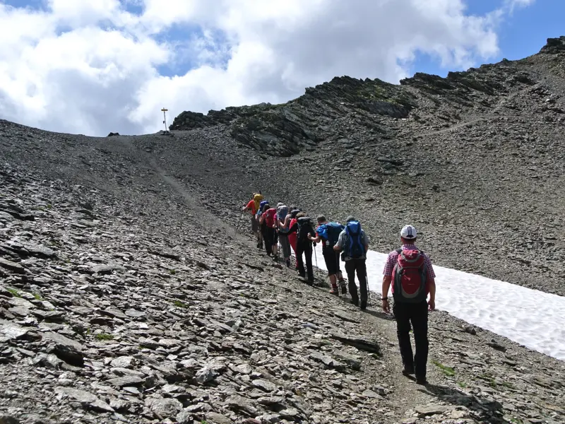 Eine Hauser-Reisegruppe beim anspruchsvollen Aufstieg über ein Geröllfeld zur Pfandlscharte in den Hohen Tauern.