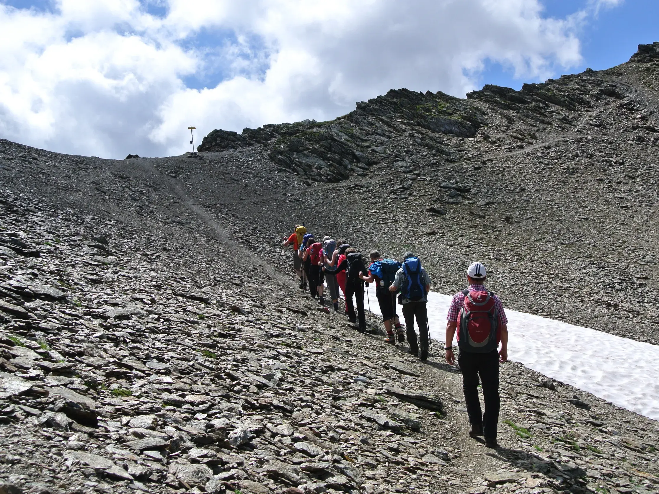 Hauser-Wandergruppe beim anspruchsvollen Aufstieg zur Pfandlscharte über ein steiles Geröllfeld im Nationalpark Hohe Tauern.