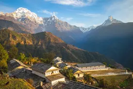 Das Bergdorf Ghandrung bei Sonnenaufgang mit Blick auf das schneebedeckte Annapurna-Massiv und den Gipfel des Machapuchare.