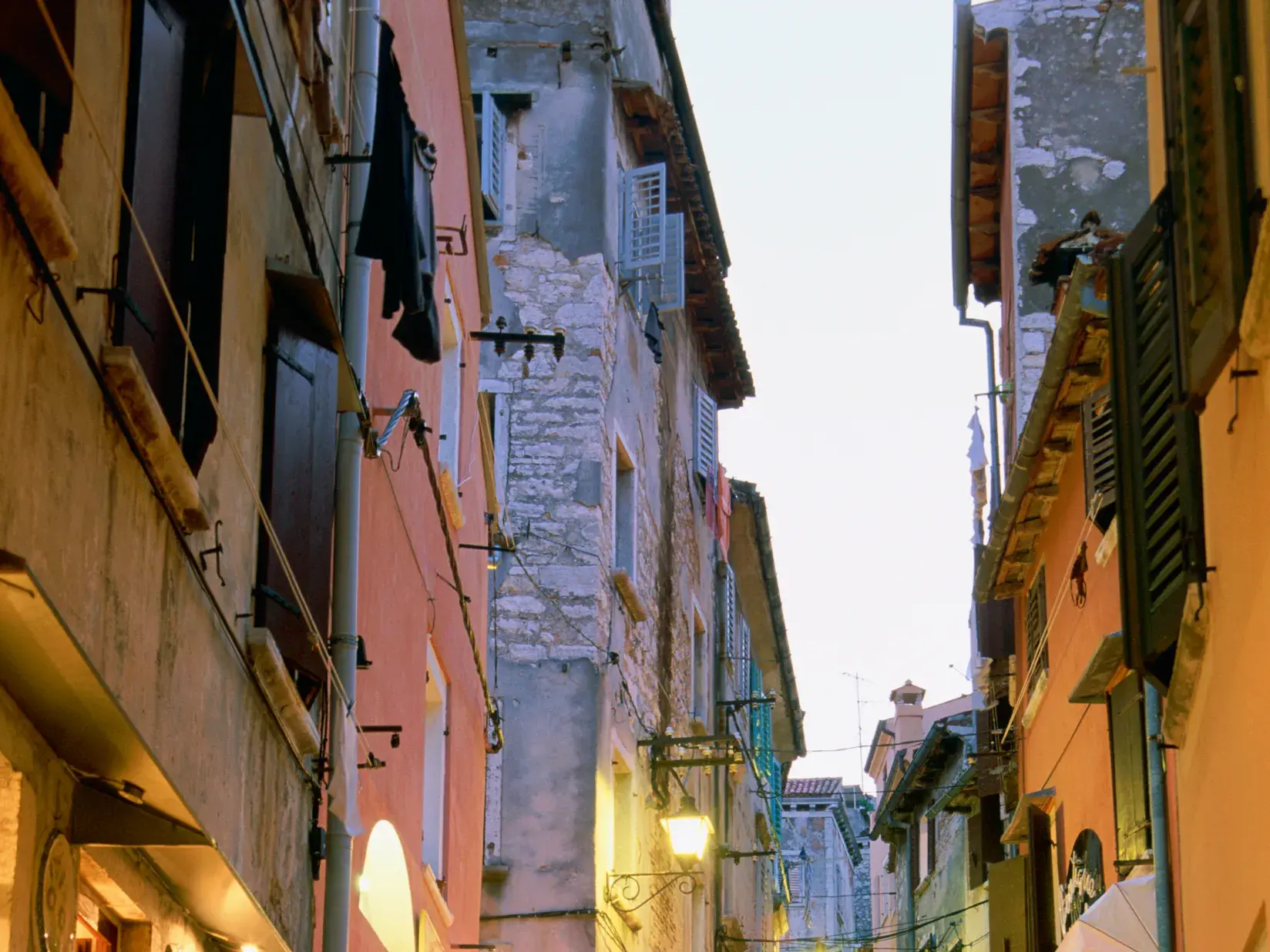 Stimmungsvoll beleuchtete Gasse mit historischen Häusern und venezianischem Flair in der Altstadt von Rovinj bei Abenddämmerung.