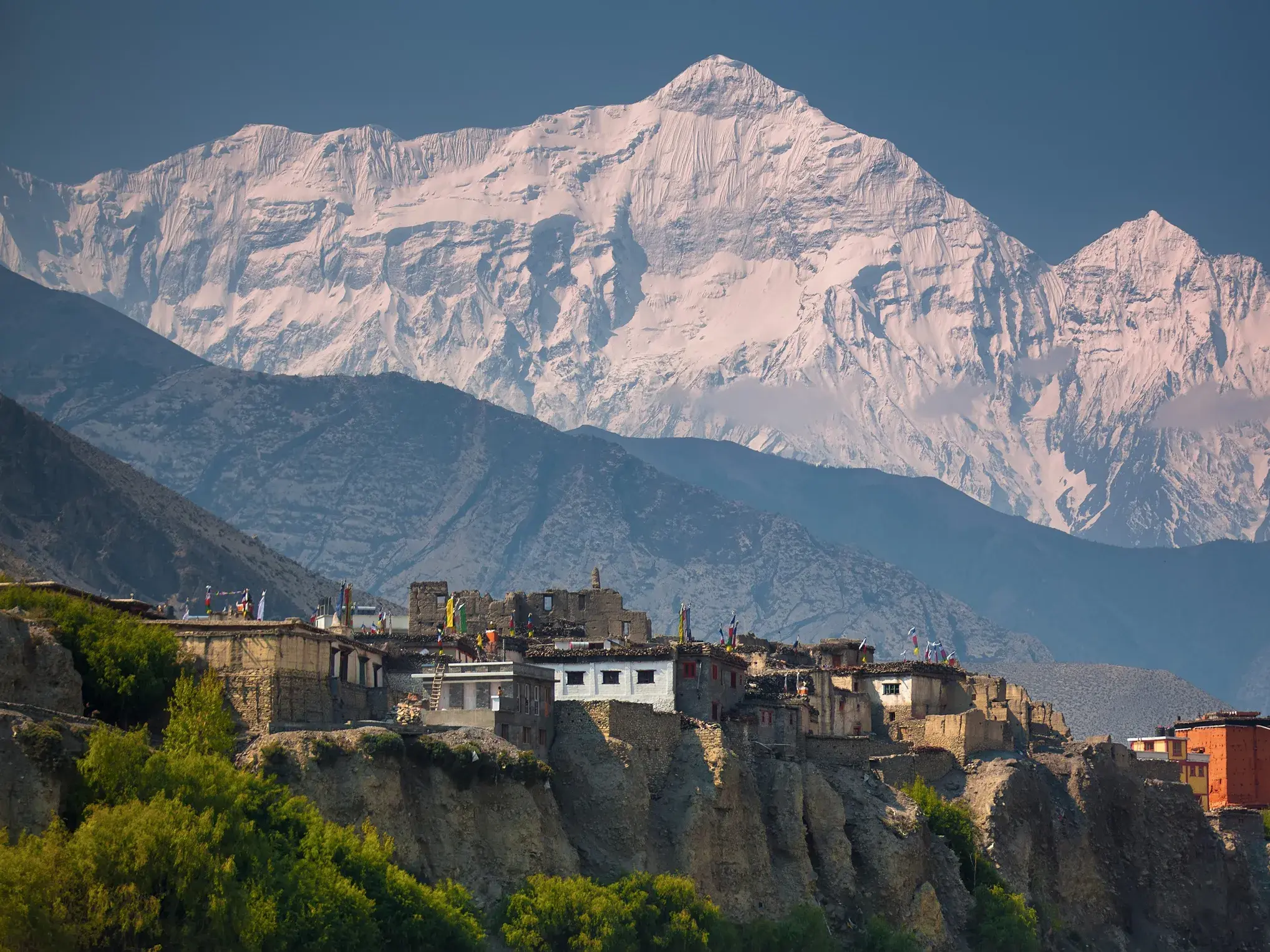 Trekking-Etappenziel Kagbeni in Mustang mit Steinhäusern am Kali Gandaki Tal, überragt vom schneebedeckten Nilgiri-Massiv.