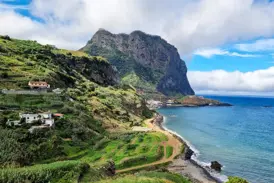 Wanderung entlang der grünen Steilküste Madeiras mit Panoramablick auf den Atlantik und den Ort Porto da Cruz.