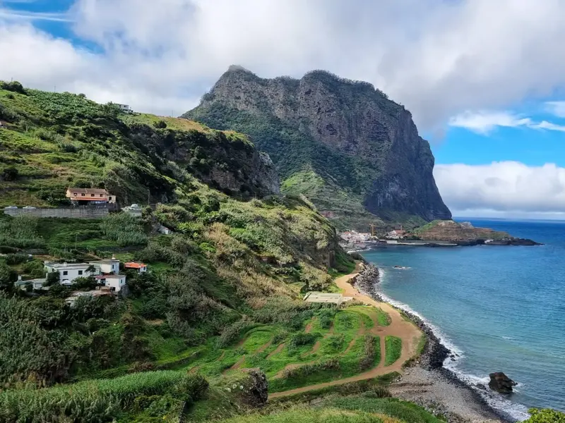 Wanderweg entlang der grünen Steilküste Madeiras mit Blick auf den imposanten Adlerfelsen und den Atlantik bei Porto da Cruz.