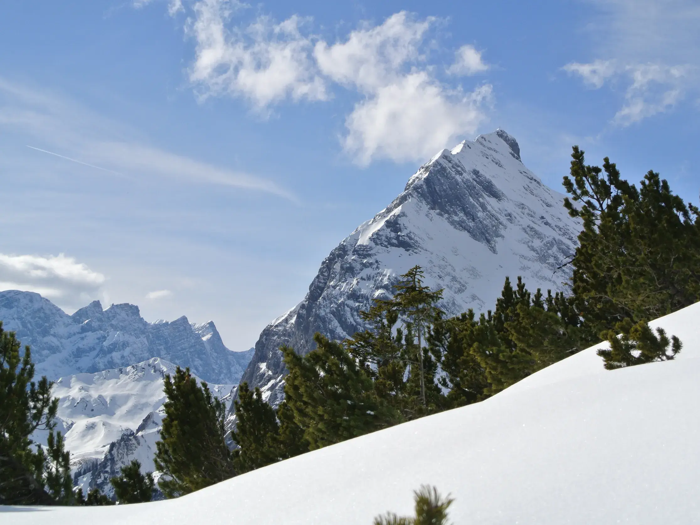 Blick beim Schneeschuhwandern im Karwendel auf den verschneiten Gipfel des Schafreiter an einem sonnigen Wintertag.