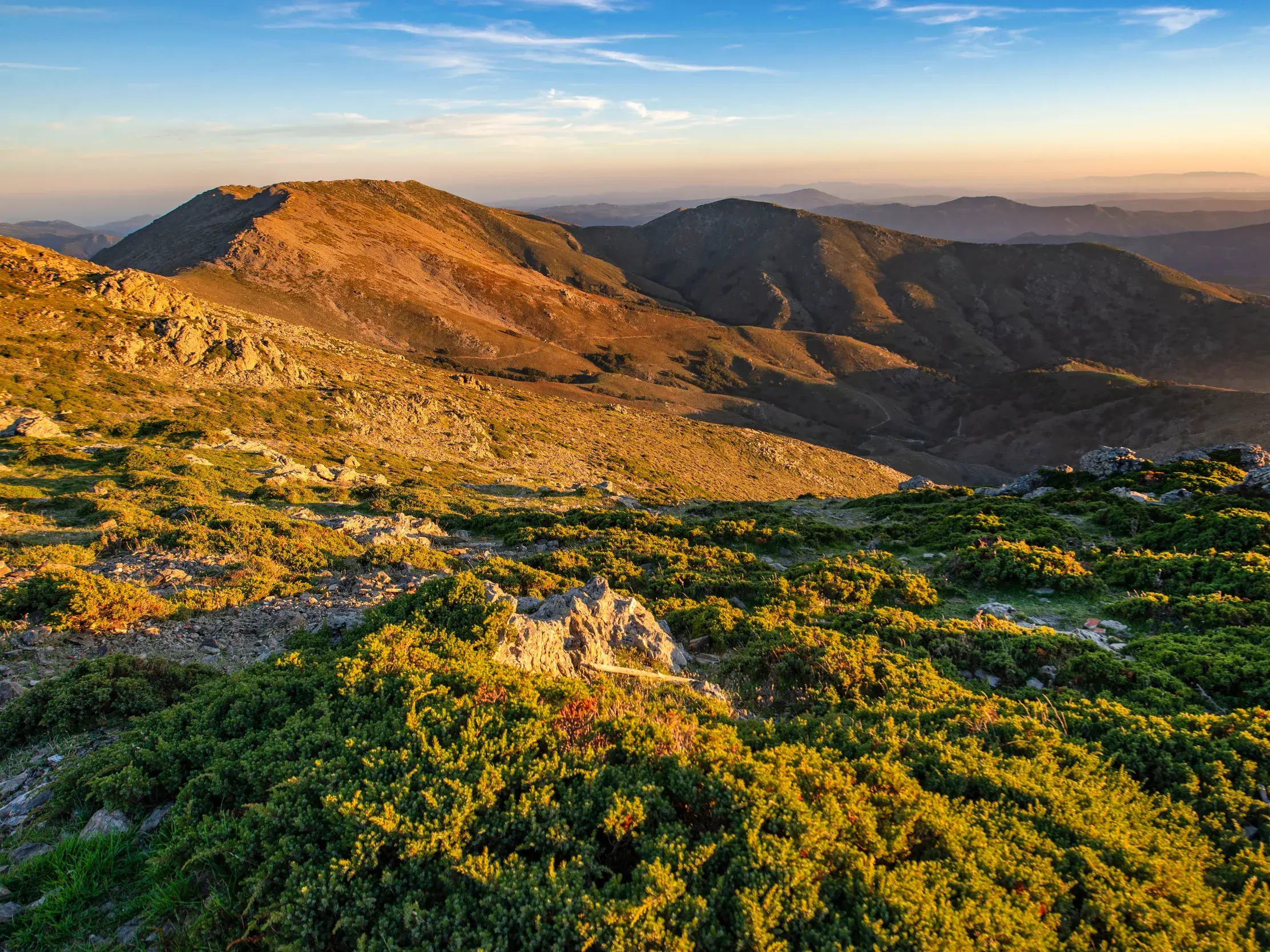 Panoramablick beim Wandern im Supramontegebirge auf Sardinien, die Berggipfel im goldenen Licht des Sonnenaufgangs.