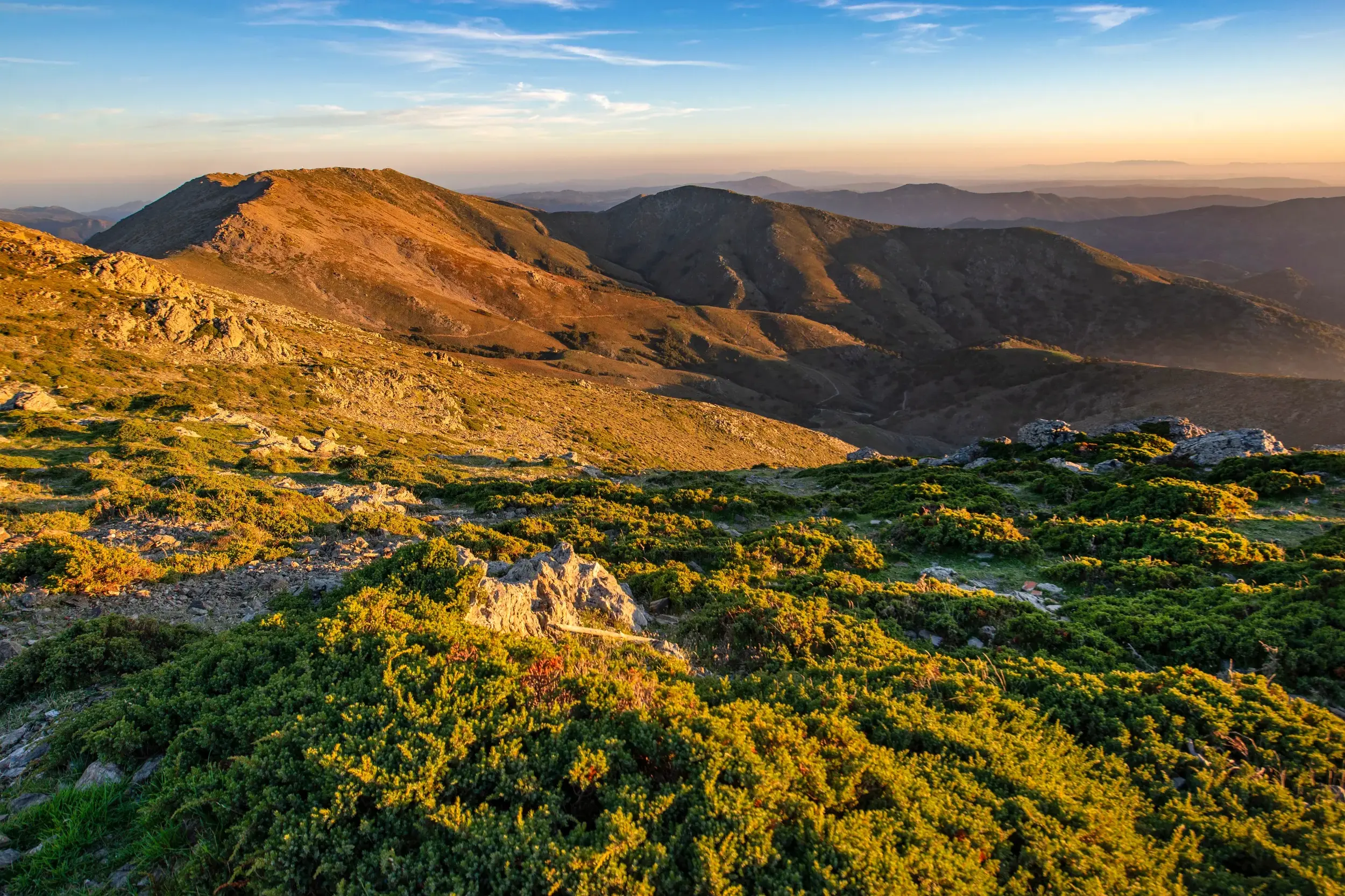 Panoramablick beim Wandern im Supramontegebirge auf Sardinien, die Berggipfel im goldenen Licht des Sonnenaufgangs.