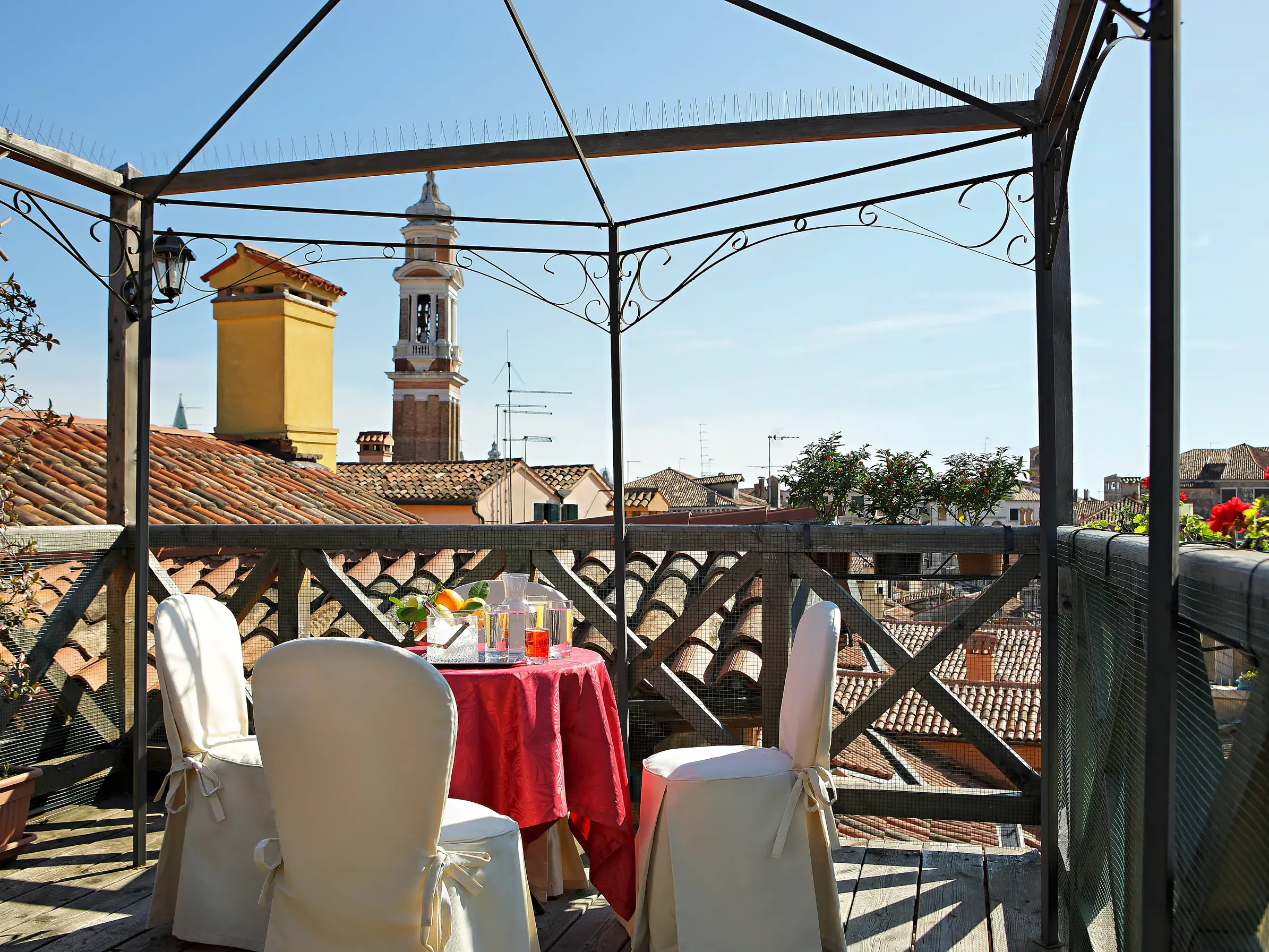 Gedeckter Tisch auf der charmanten Dachterrasse des Hotels Ca' d'Oro mit malerischem Blick über die Dächer Venedigs.