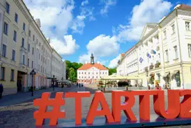 Historischer Rathausplatz in der estnischen Universitätsstadt Tartu an einem sonnigen Tag mit der #TARTU2024-Skulptur.