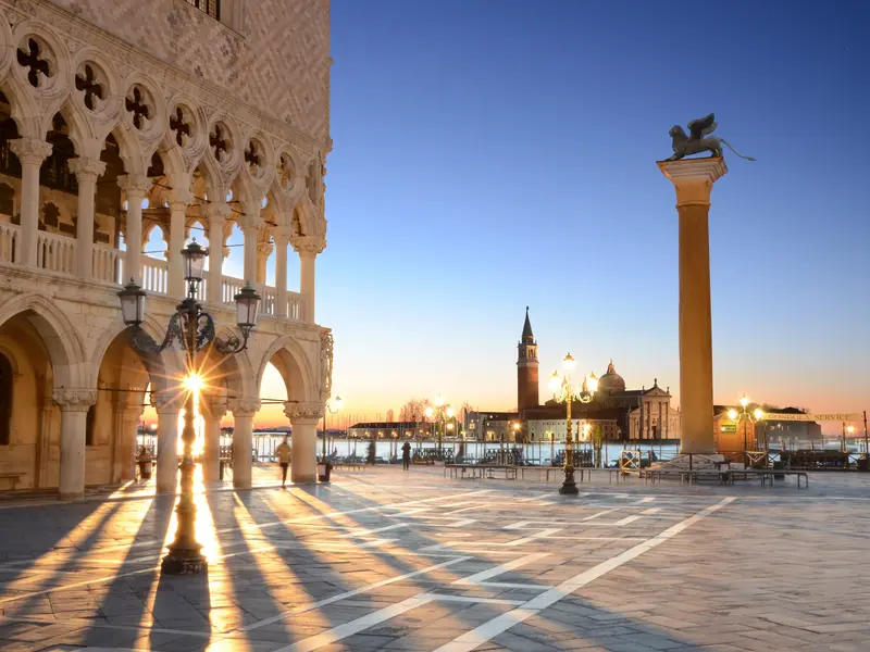 Goldene Morgensonne am Markusplatz mit Blick auf den Dogenpalast, die Markussäule und San Giorgio Maggiore in Venedig.