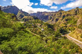 Weitblick beim Wandern über das grüne Paul-Tal auf Santo Antão mit üppiger Vegetation und schroffer Bergkette am Horizont.