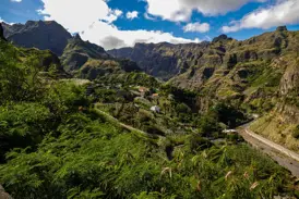 Üppig grüne Terrassenfelder und ein kleines Dorf im Paúl-Tal, eingerahmt von der schroffen Bergwelt auf Santo Antão, Kapverden.