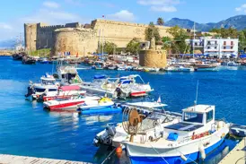 Malerischer Hafen von Kyrenia in Nordzypern mit vielen Booten im blauen Wasser vor der imposanten mittelalterlichen Festung.