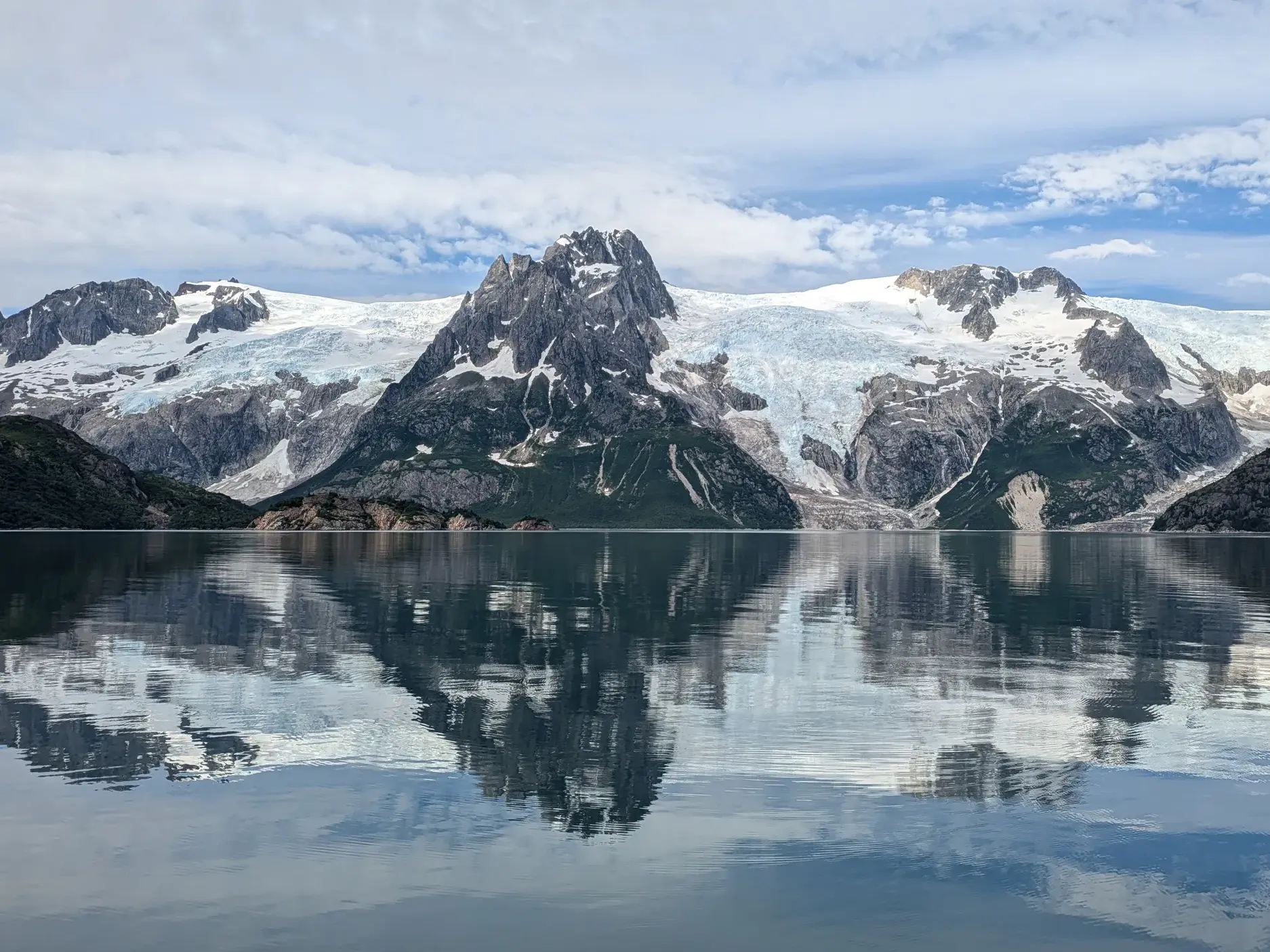 Majestätische Gletscher der Berge im Kenai Fjords Nationalpark spiegeln sich im ruhigen Wasser des Fjords in Alaska.