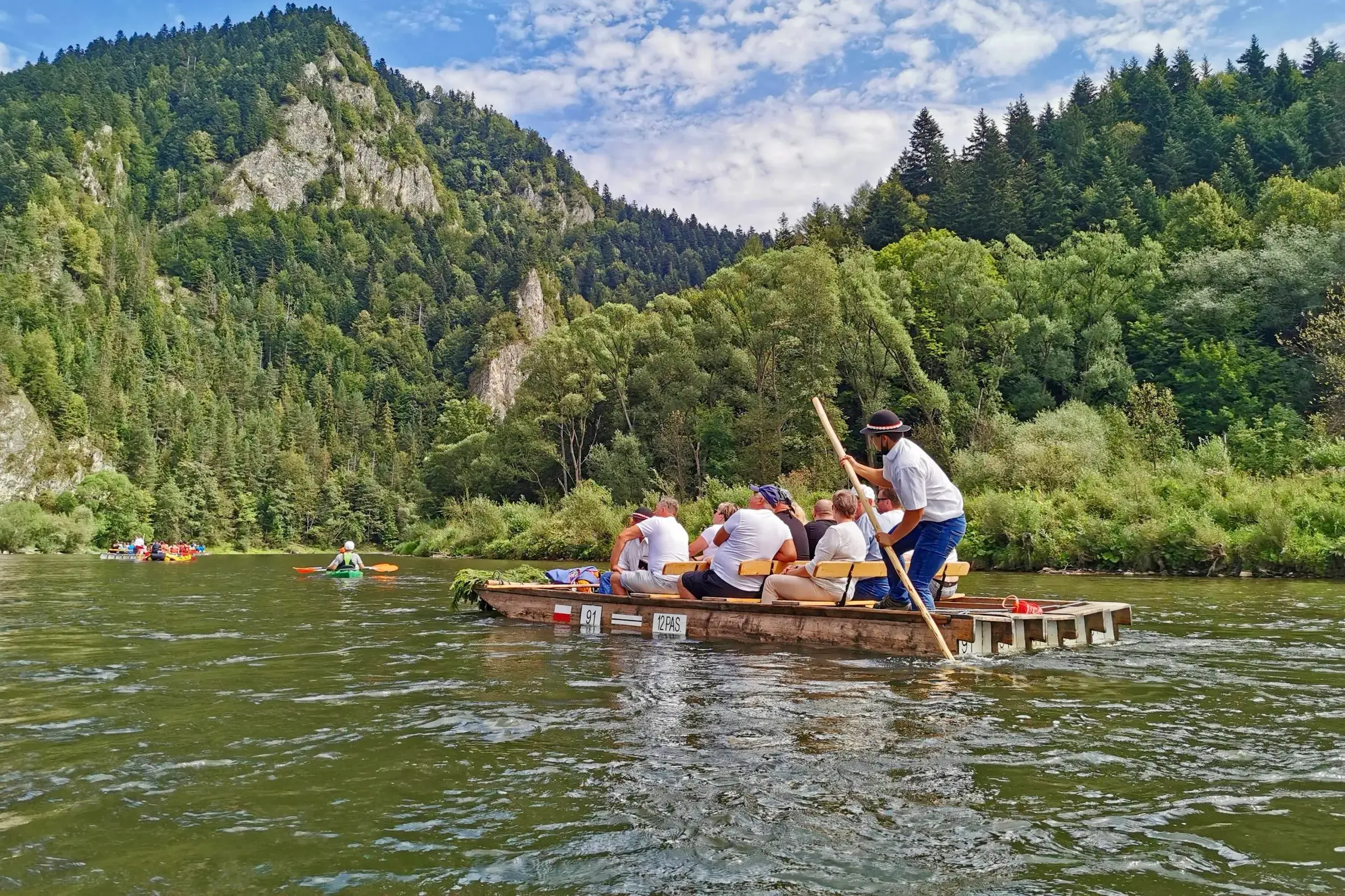 Reisegruppe auf einer traditionellen Floßfahrt auf dem Dunajec durch die Schlucht des Pieniny-Nationalparks in Polen.