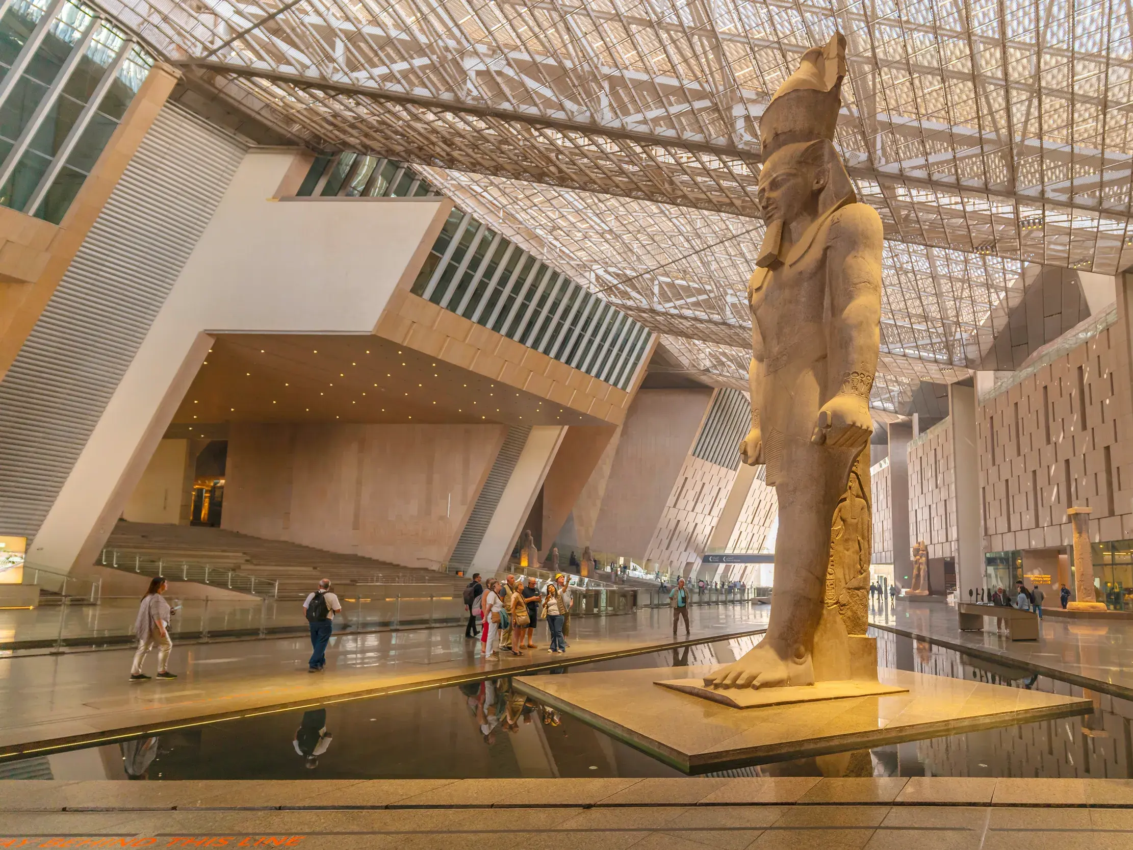 Kolossale Statue von Ramses II. in der modernen, lichtdurchfluteten Eingangshalle des Grand Egyptian Museum in Gizeh.