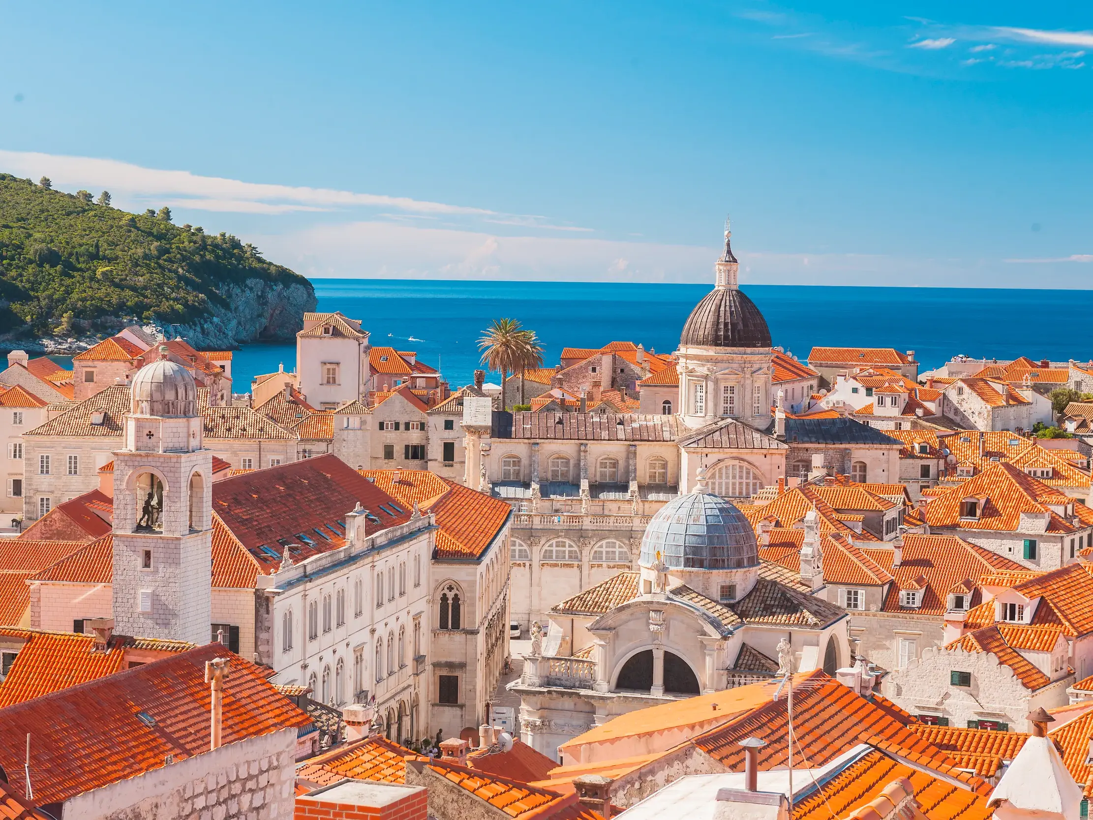 Sonniger Blick von der Festungsmauer über die Altstadt von Dubrovnik mit ihren roten Dächern und Kirchtürmen zur Adria.