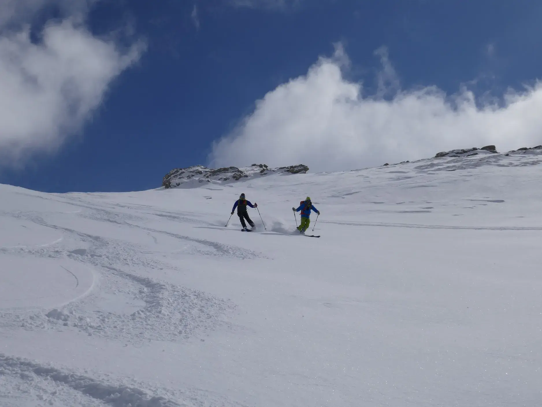 Zwei Skitourengeher genießen die Abfahrt auf einem weiten, unberührten Schneehang im Sharr-Gebirge im Kosovo.