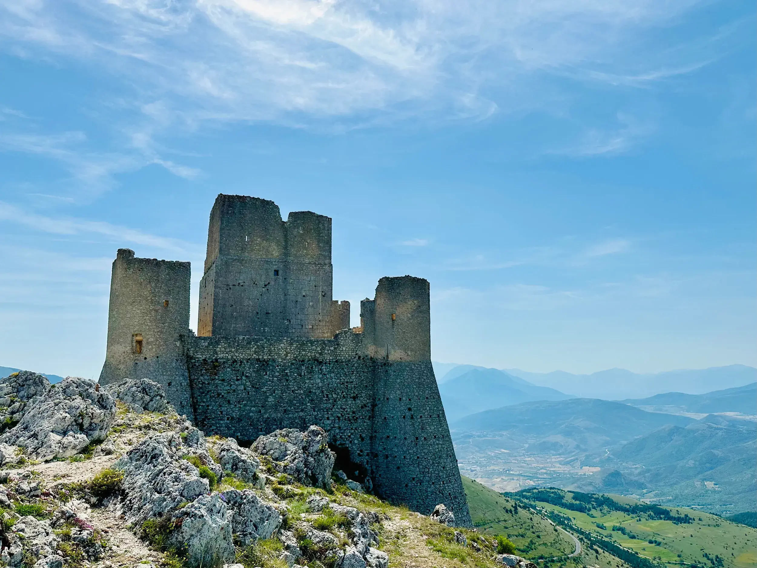 Wanderung zur Burgruine Rocca Calascio mit Panoramablick auf die weite Berglandschaft des Nationalparks Gran Sasso.