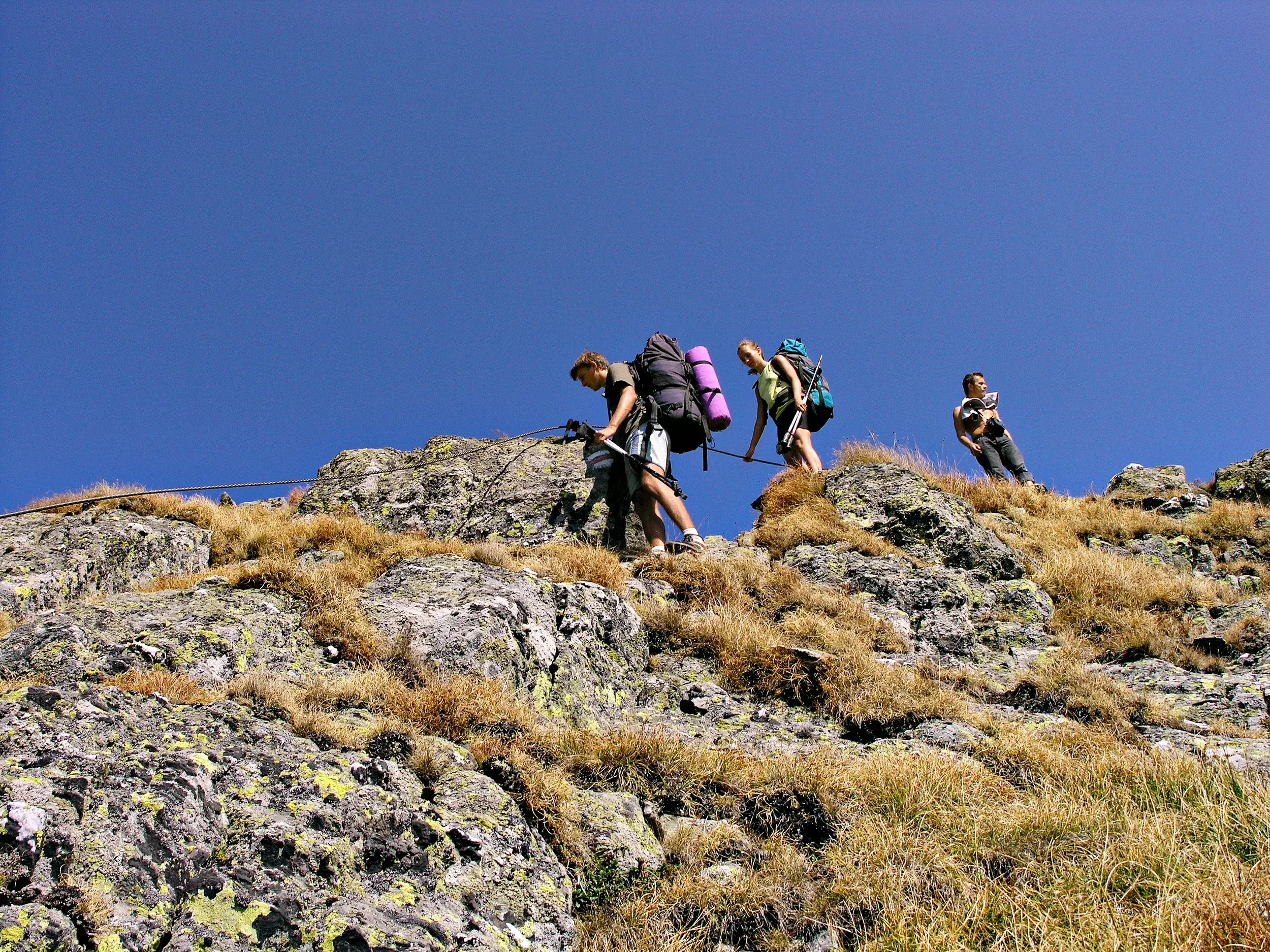 Eine kleine Trekkinggruppe überquert einen seilgesicherten Felsgrat im Fagaras Gebirge in den rumänischen Karpaten.