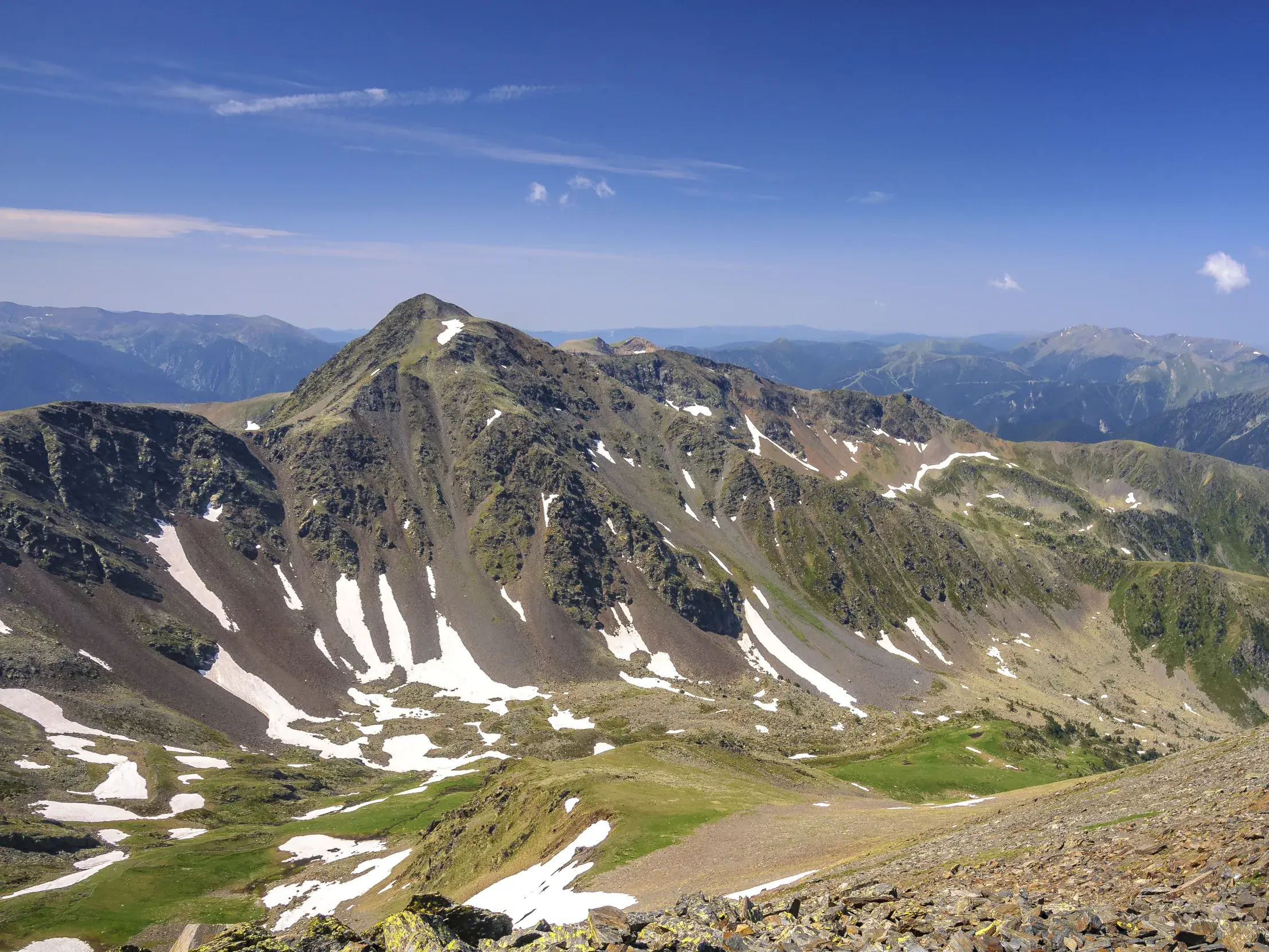 Weite Aussicht beim Trekking in Andorra auf den Gipfel des Pic de Montmalús und die umliegende Berglandschaft der Pyrenäen.