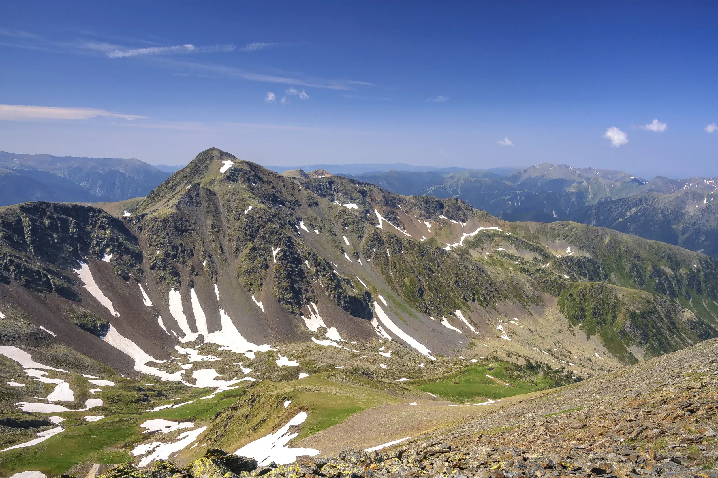 Weite Aussicht beim Trekking in Andorra auf den Gipfel des Pic de Montmalús und die umliegende Berglandschaft der Pyrenäen.