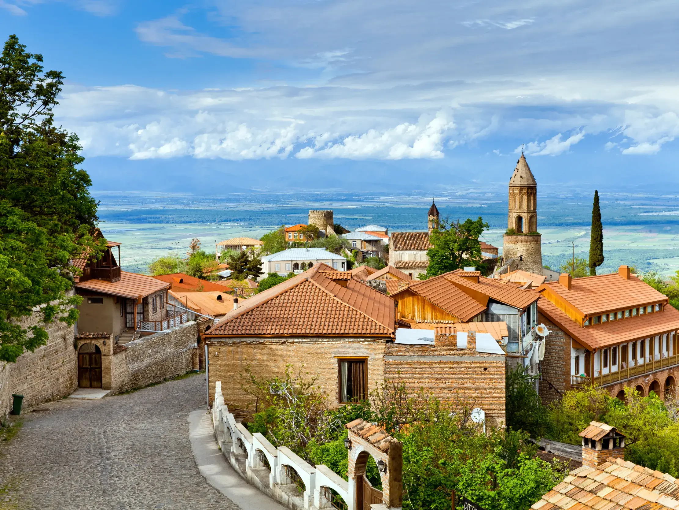 Historische Altstadt von Signagi in Georgien mit Kirchturm und Blick von der Stadtmauer über das weite Alasanital.