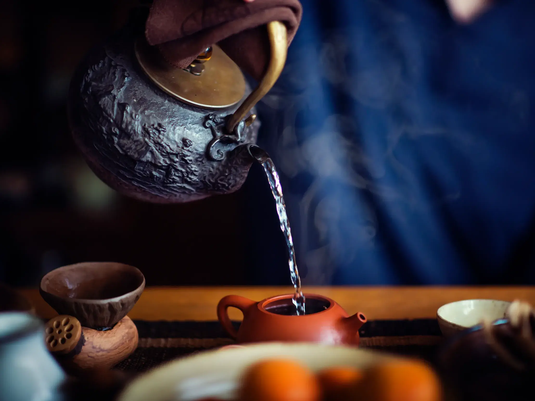 Authentische Teezeremonie während einer Studienreise in China: Heißes Wasser wird in eine traditionelle Tonteekanne gefüllt.