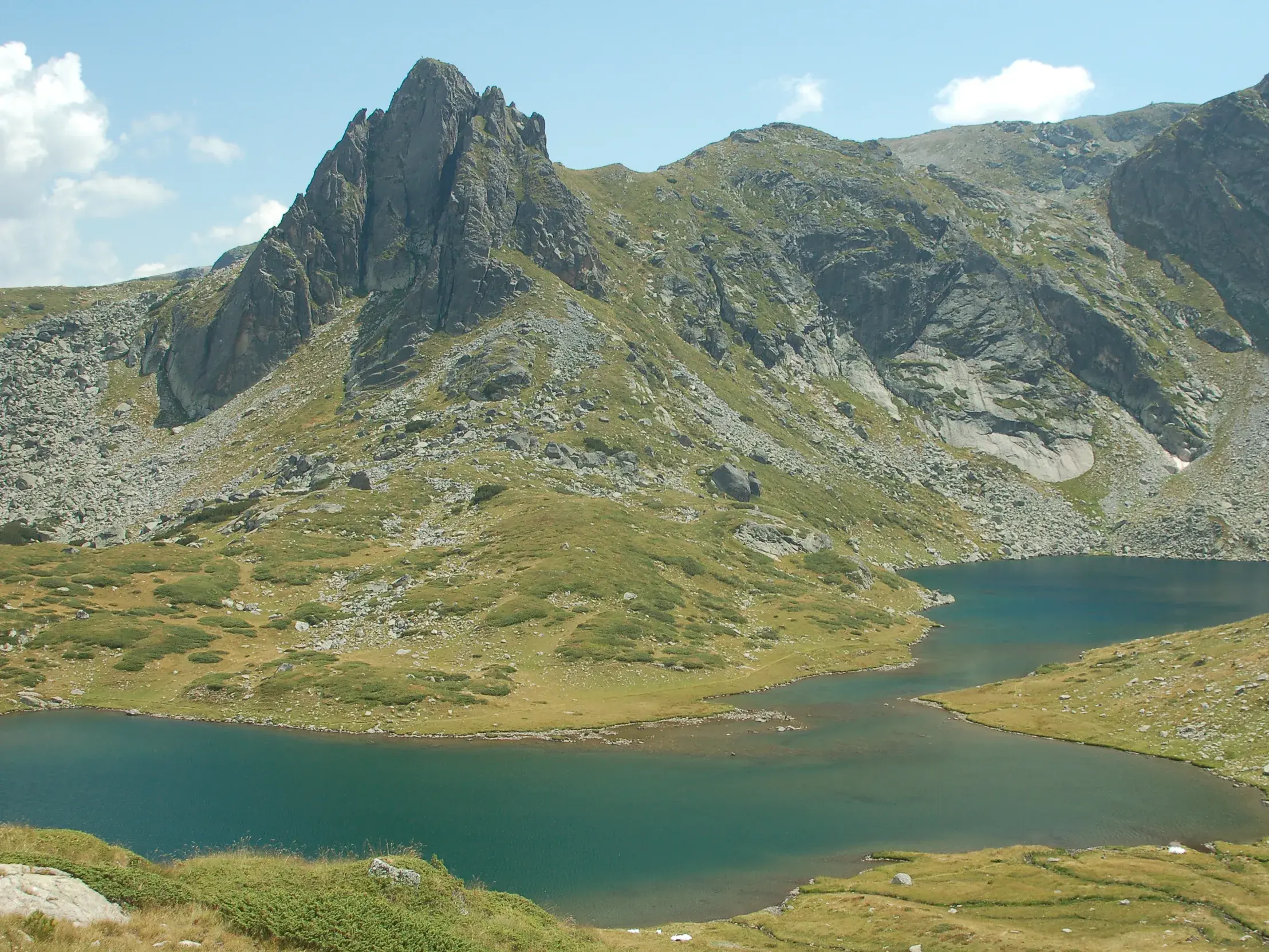 Panoramablick auf einen der Sieben Rila-Seen, eingebettet in die karge Felslandschaft des Rila-Nationalparks in Bulgarien.
