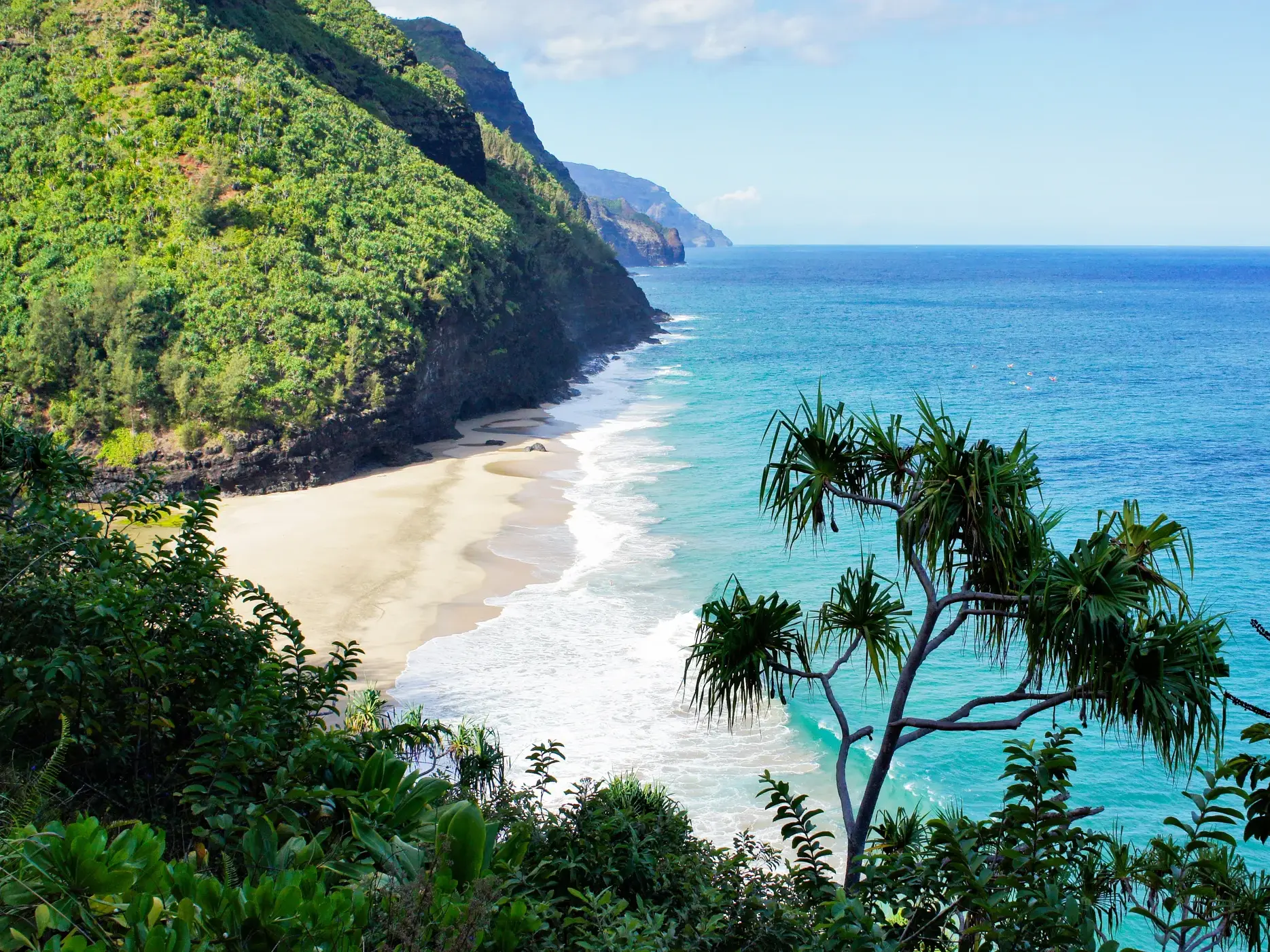 Hoher Aussichtspunkt auf einer Wanderung an der Napali-Küste mit Blick auf die grünen Klippen, Sandstrand und Pazifik auf Kauai.