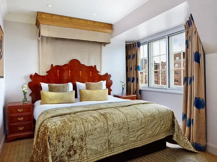 Komfortables Doppelzimmer im Hotel Radisson Blu London Euston Square mit Holzbett und Blick auf die Londoner Architektur.