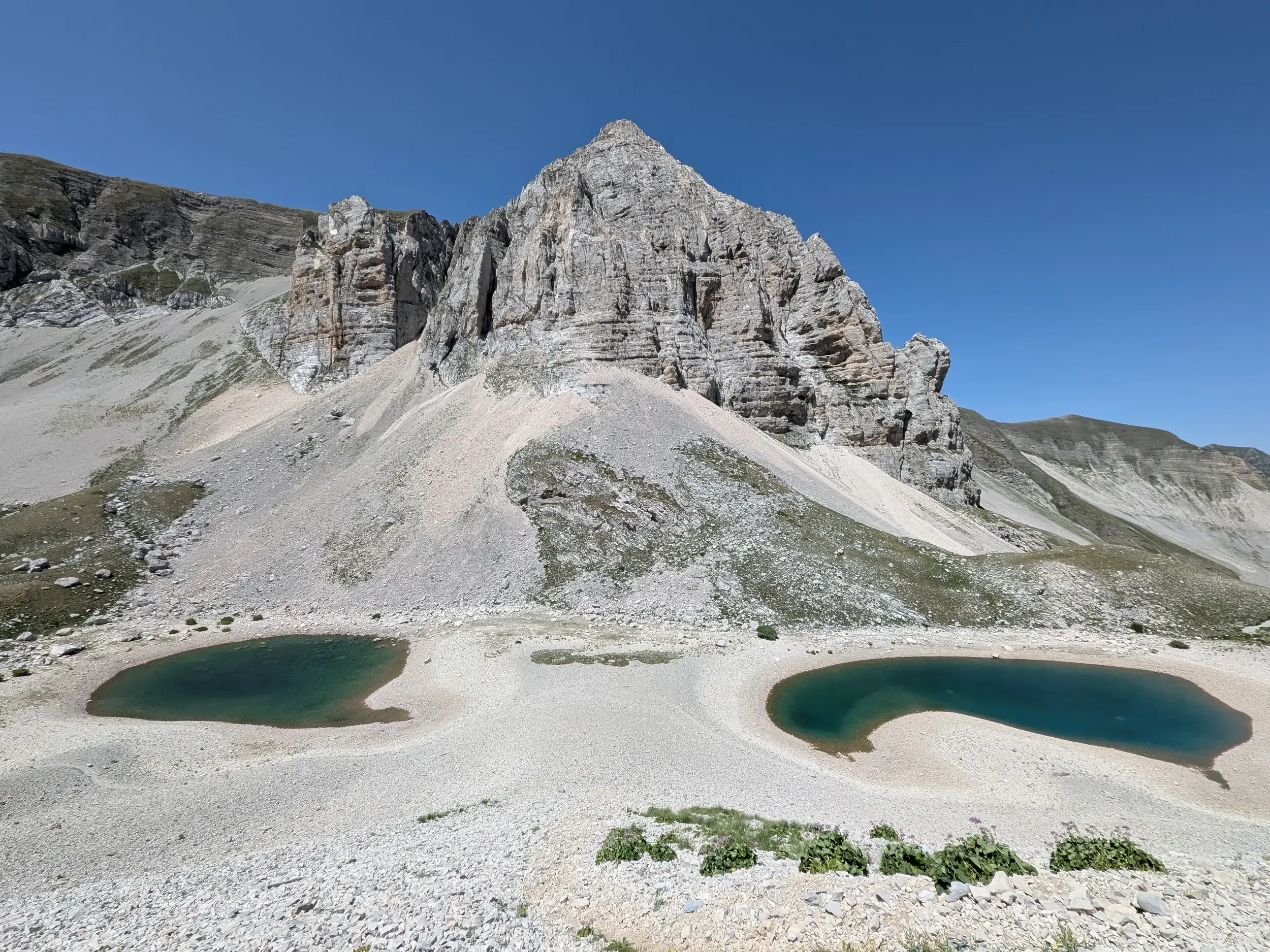 Die beiden Becken des Pilatus Sees vor der beeindruckenden Felskulisse des Monte Vettore im Nationalpark Monti Sibillini.