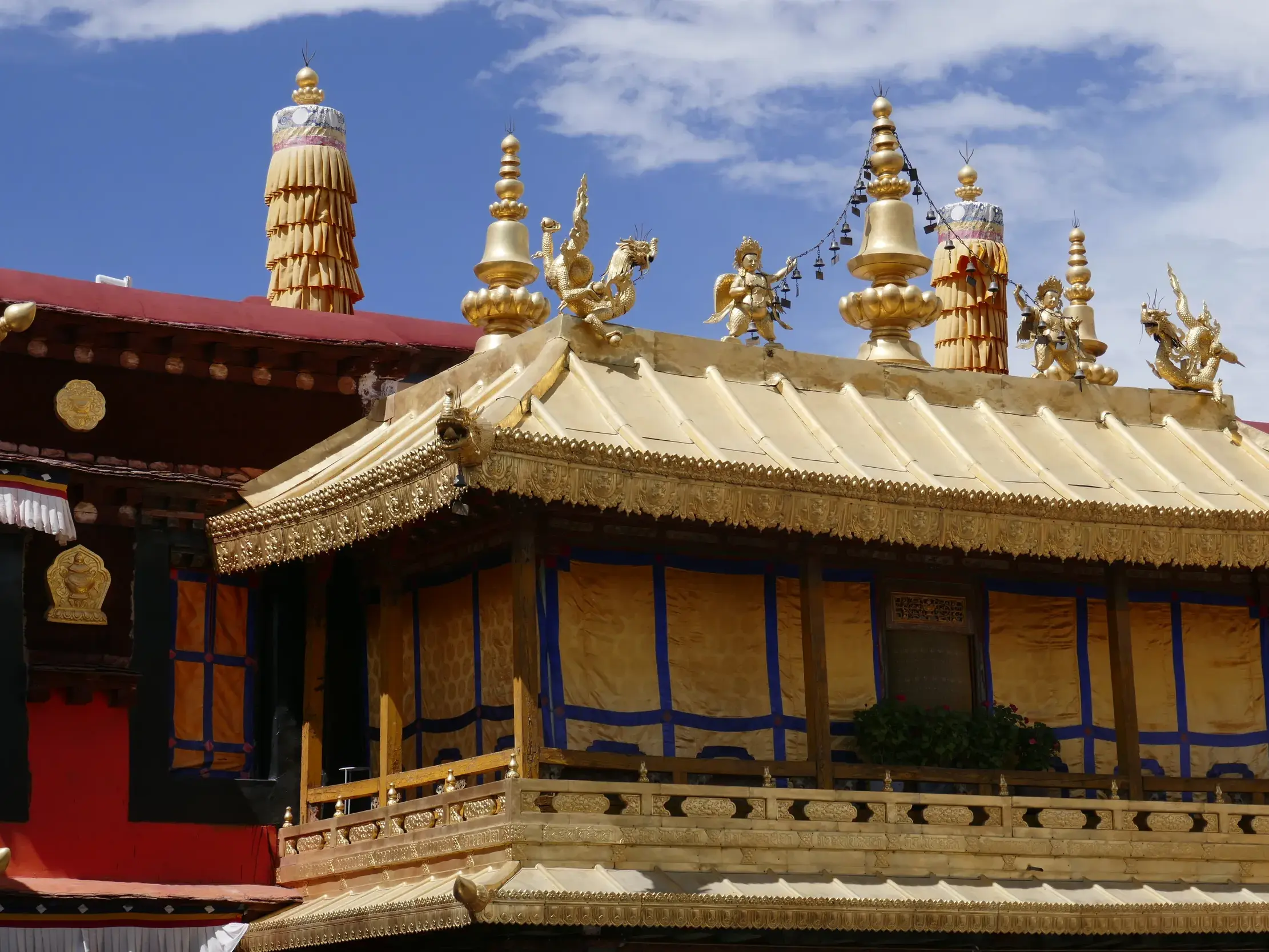 Detailaufnahme der goldenen Dächer des heiligen Jokhang-Tempels in Lhasa mit aufwendigen buddhistischen Figuren und Verzierungen.