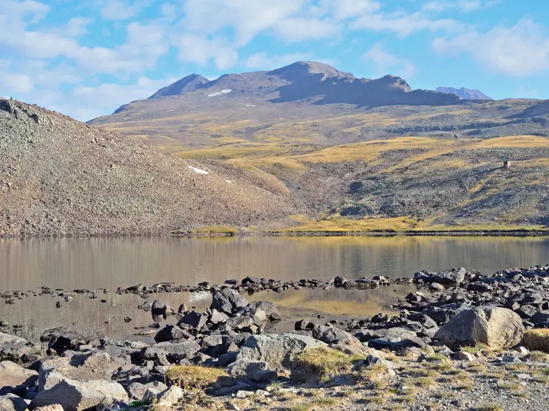 Der stille Kari-See auf 3.200 Metern Höhe vor dem Panorama des Aragats-Massivs in der Hochgebirgslandschaft Armeniens.