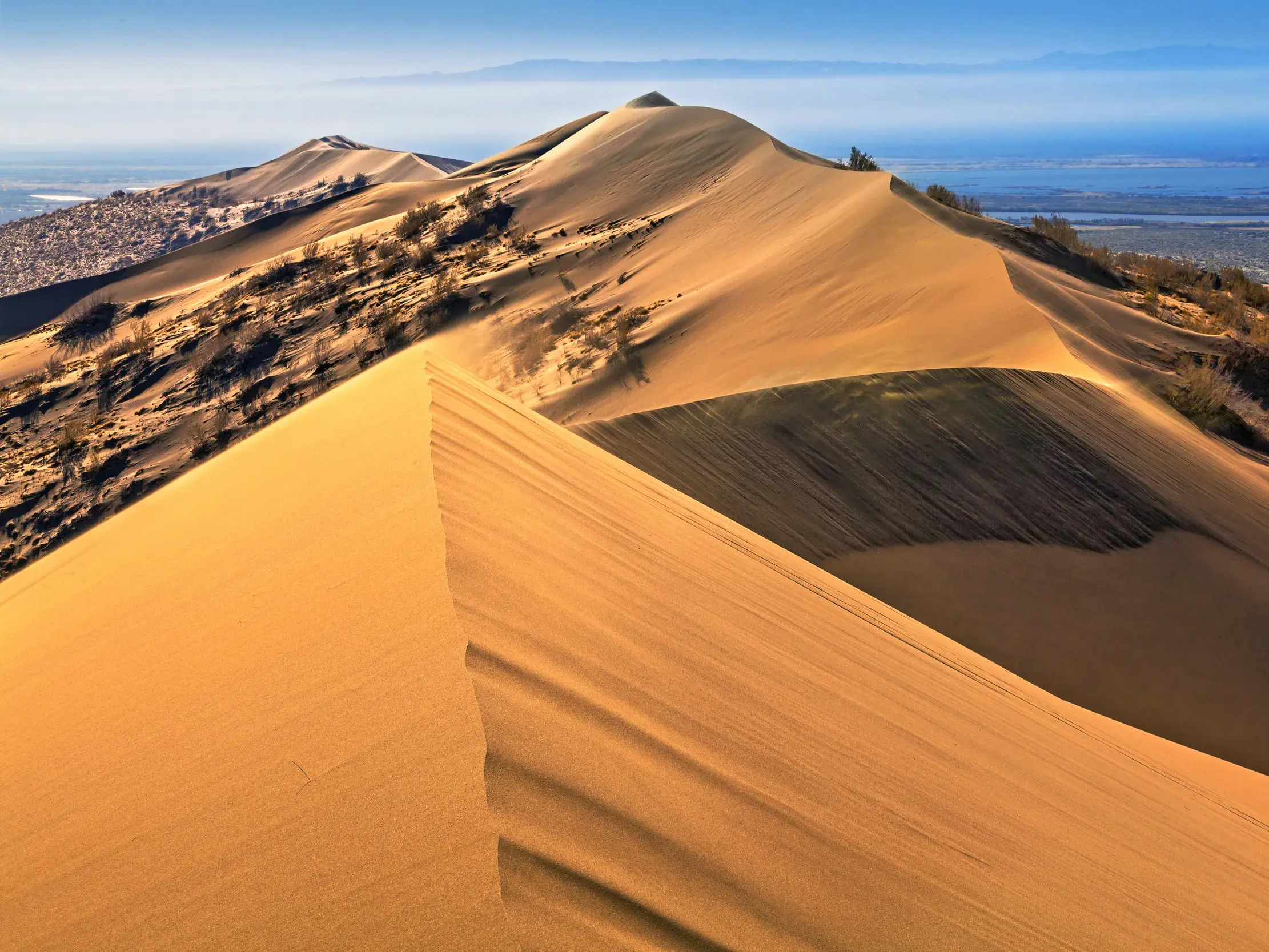 Weite Aussicht vom Grat der goldenen Singenden Düne über die Landschaft des Altyn-Emel Nationalparks in Kasachstan.