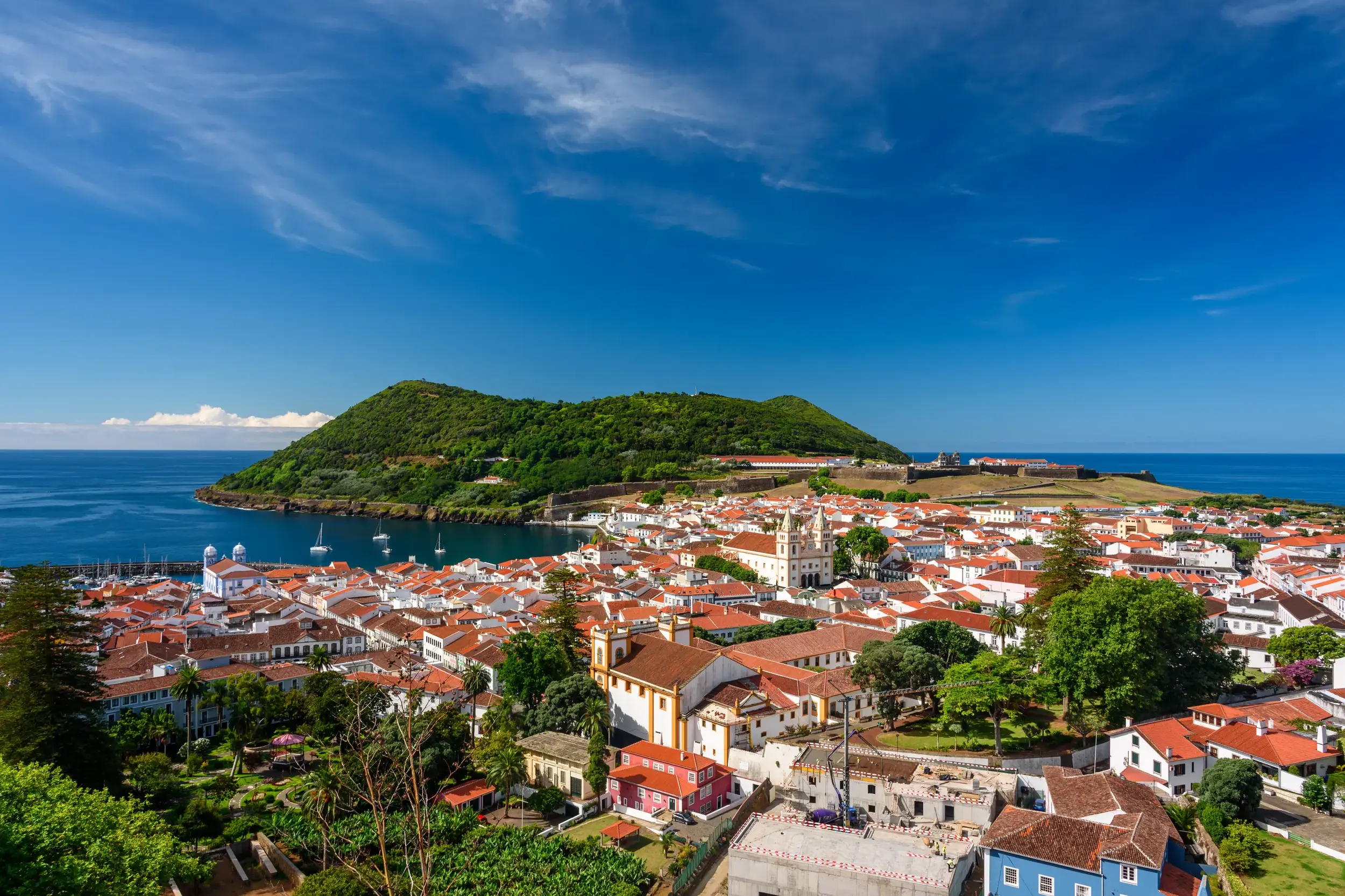Panoramablick über die Dächer der UNESCO-Stadt Angra do Heroísmo auf Terceira, die Bucht und den bewaldeten Monte Brasil.