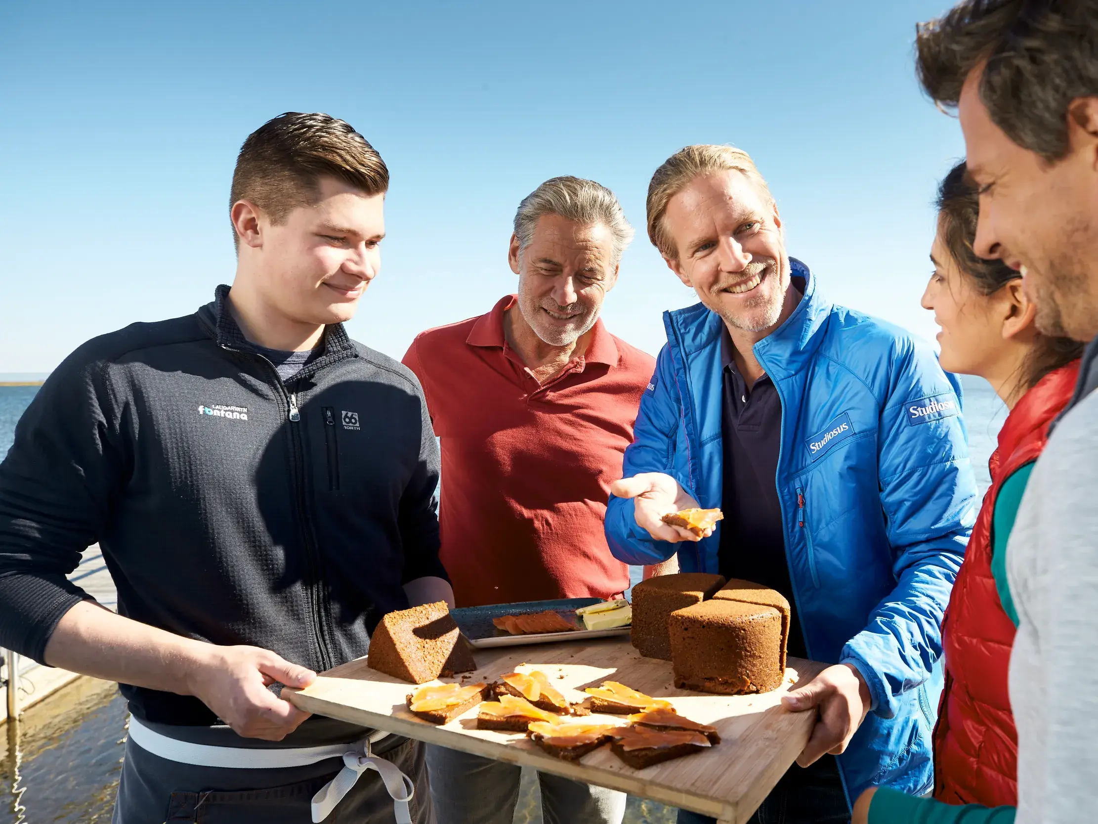 Studiosus-Reiseleiter reicht Reisegruppe traditionelles isländisches Brot zur Verkostung