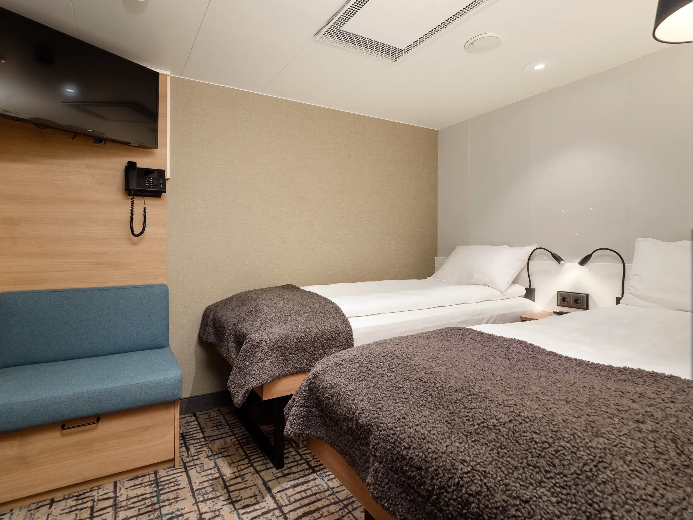 Moderne Doppelkabine mit zwei Einzelbetten und gemütlichen Decken auf dem Hurtigruten Postschiff MS Nordkapp in Norwegen.