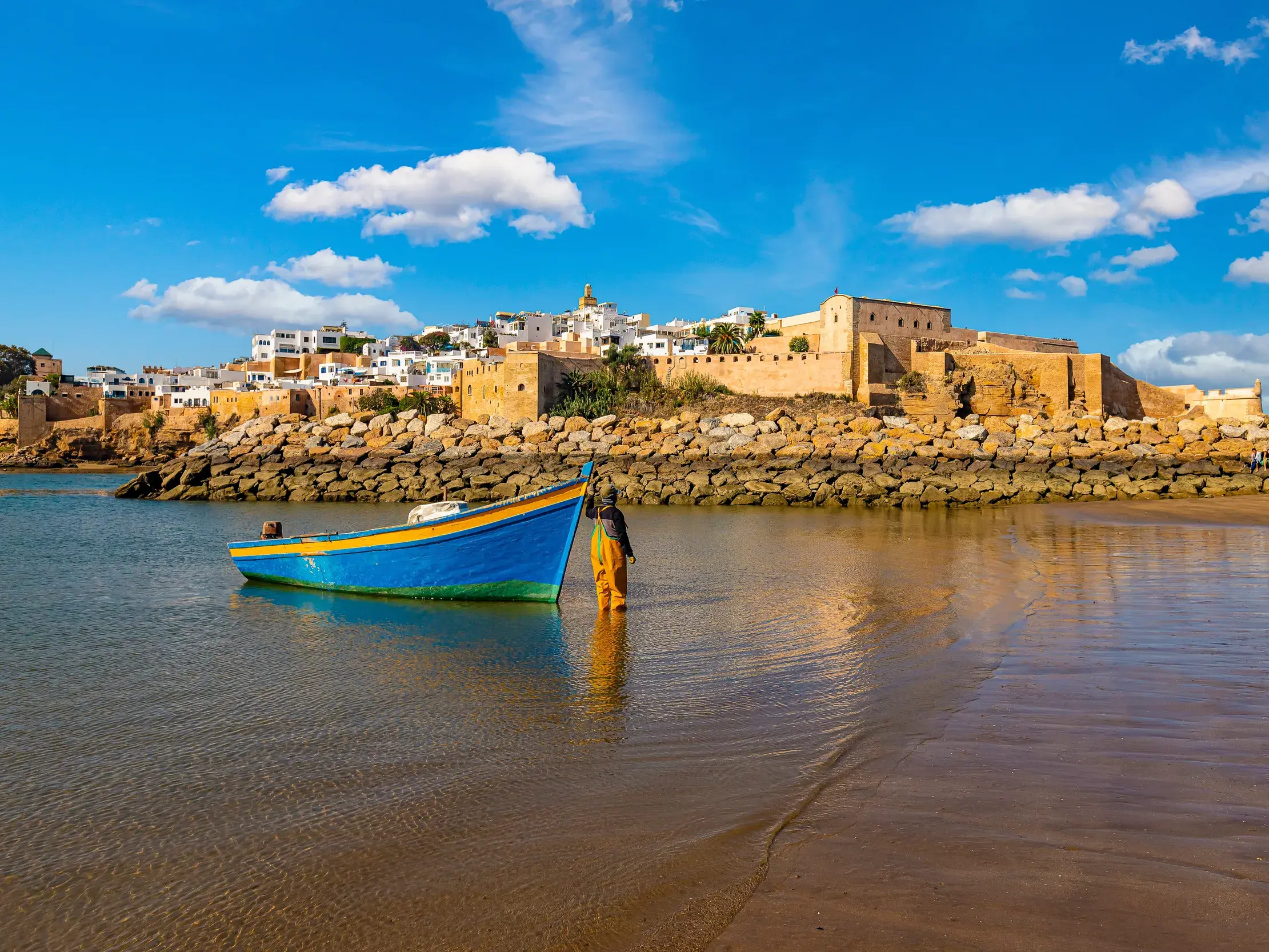 Kasbah des Oudaias in Rabat mit blauem Fischerboot im Wasser am Strand