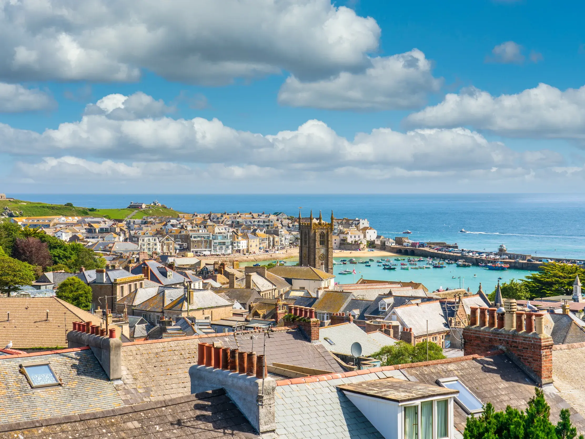 Malerischer Blick über die Dächer des Künstlerstädtchens St. Ives auf den Hafen und das türkisfarbene Meer in Cornwall.