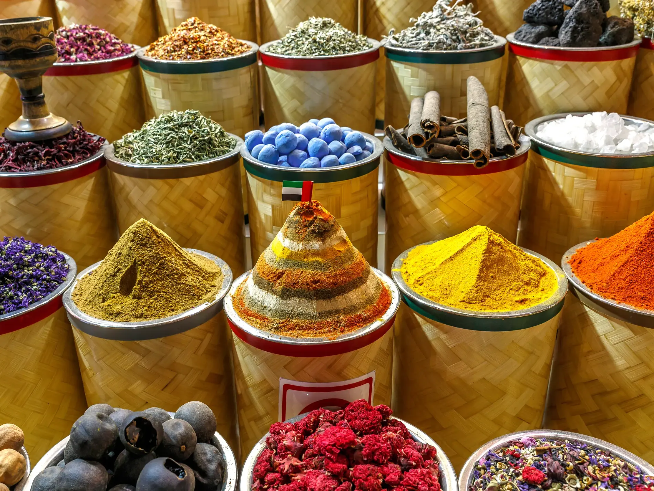 Farbenprächtige Gewürze, Kräuter und Weihrauch in Körben auf dem Souk von Muttrah kunstvoll zu Pyramiden aufgetürmt.